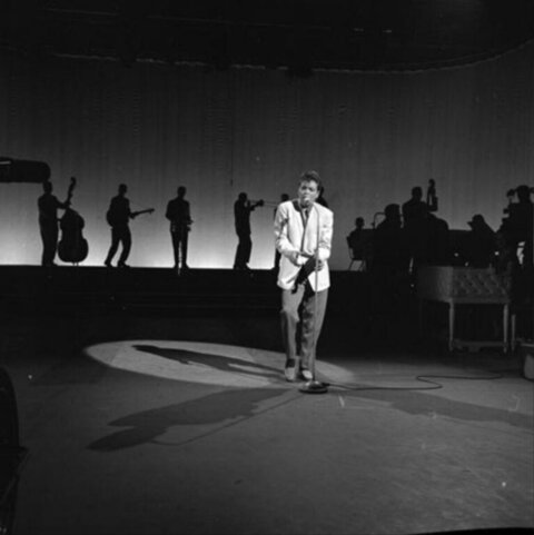Singer Performing on Stage with Band