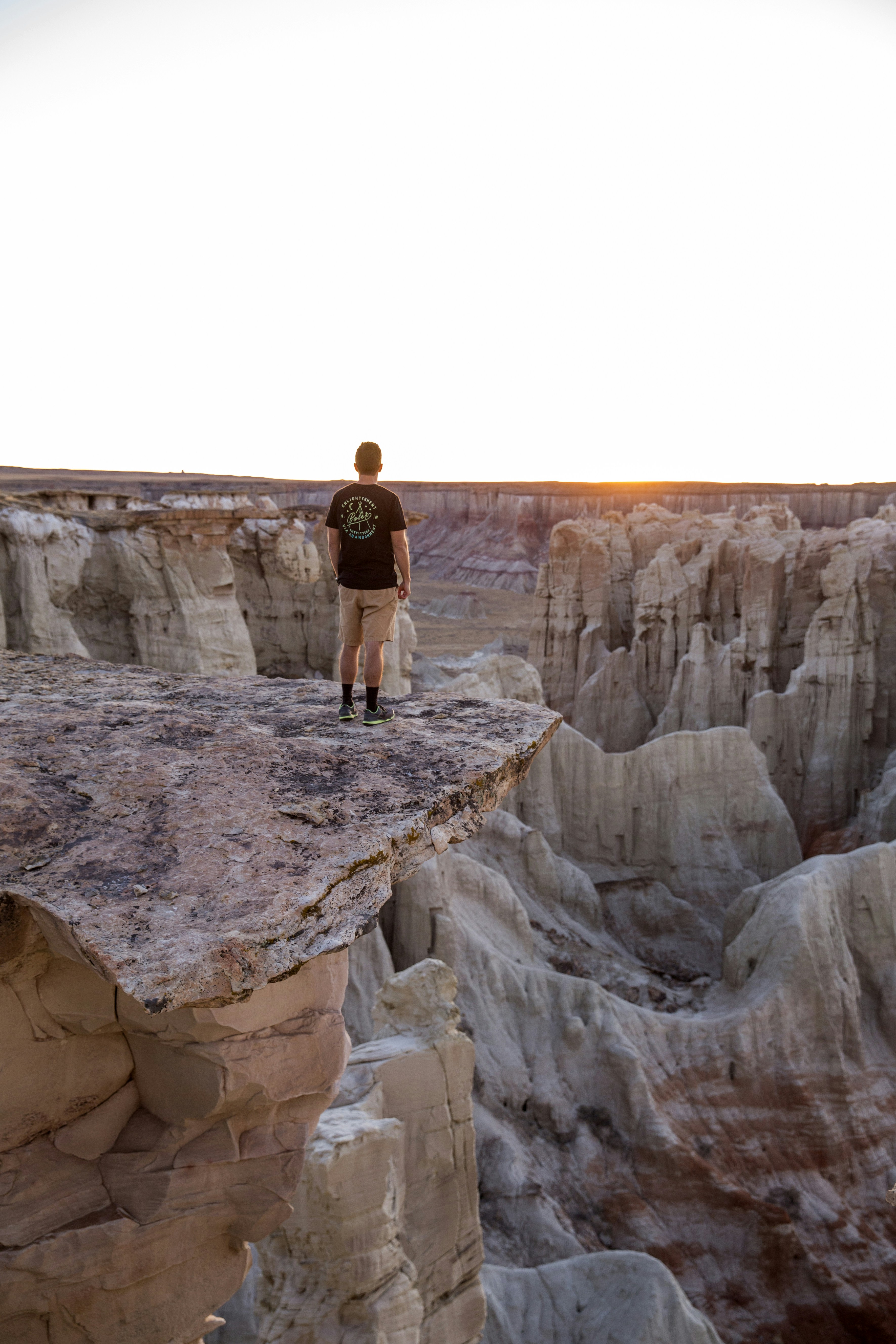 Man Standing on Cliff Overlooking Canyon