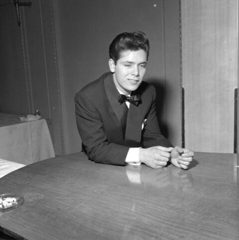 Young Man In Tuxedo Seated At Table
