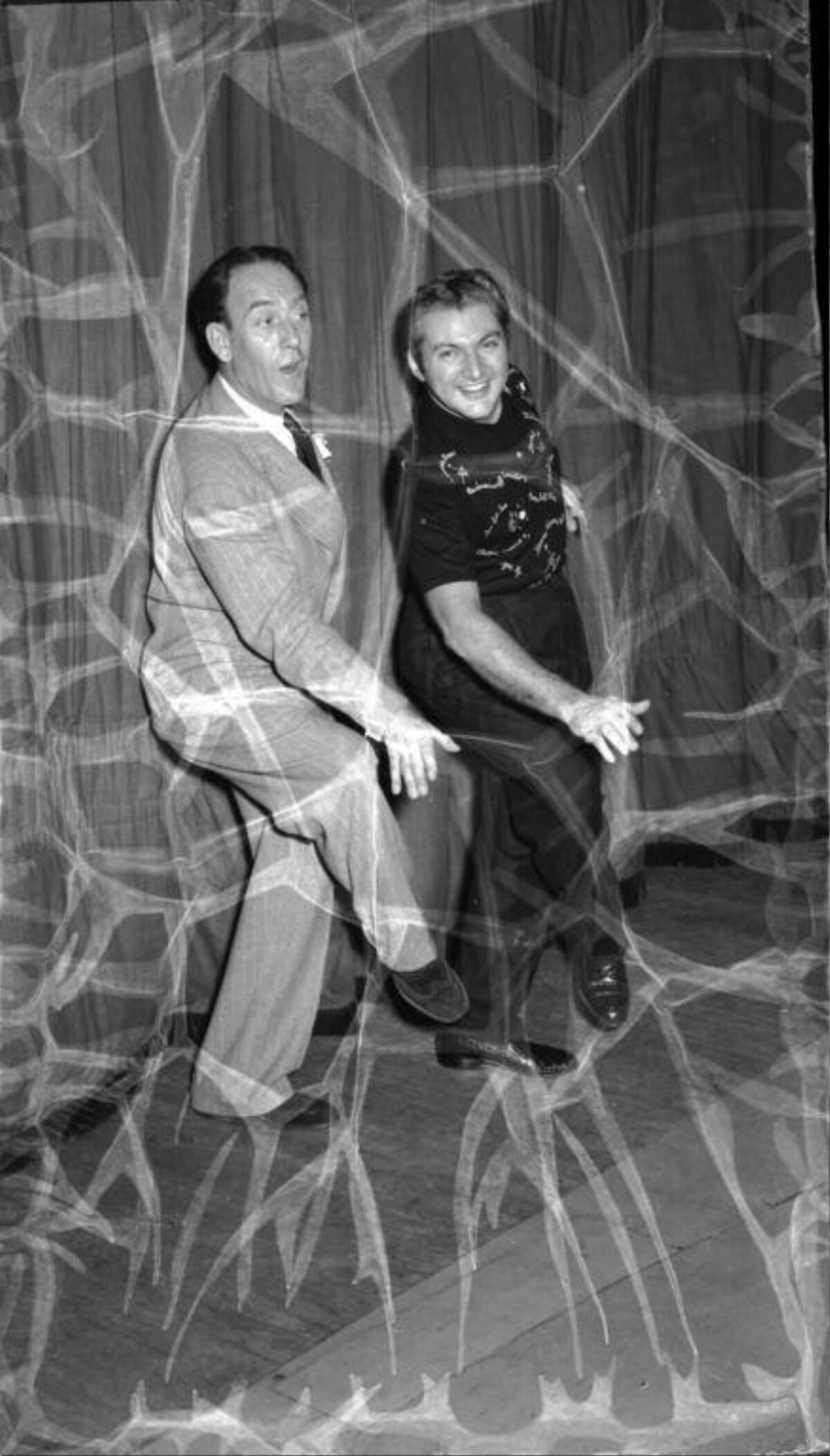Two Men Posing Behind Giant Spider Web Prop