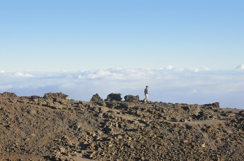 Hiker Walking Above Sea of Clouds