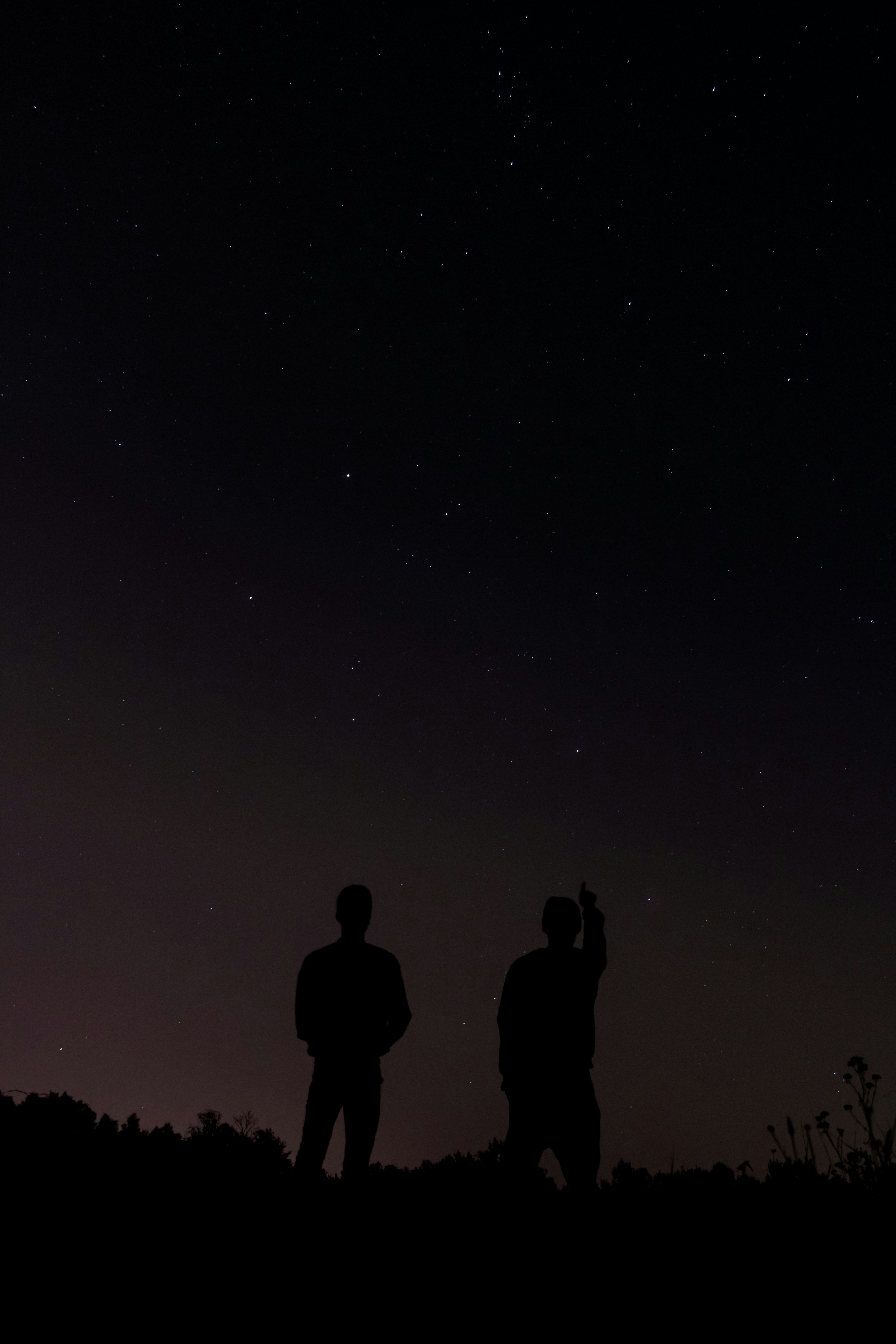 Two Silhouettes Under Starry Night Sky
