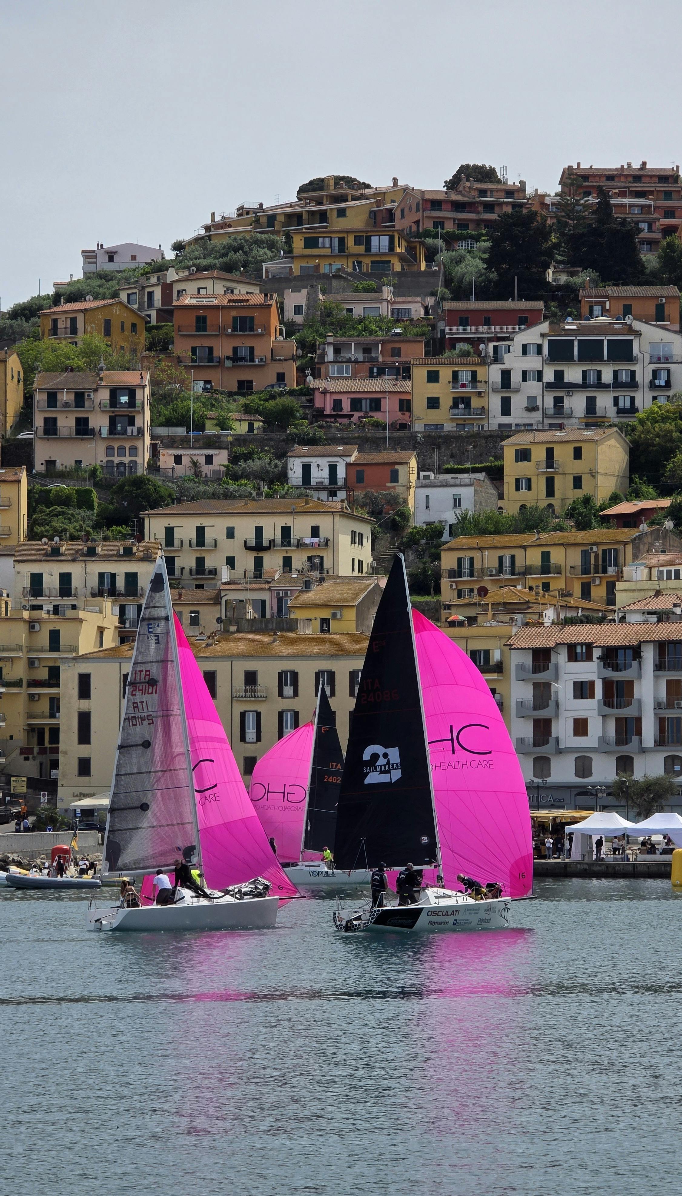 Sailboat Race off Coastal Hillside Town