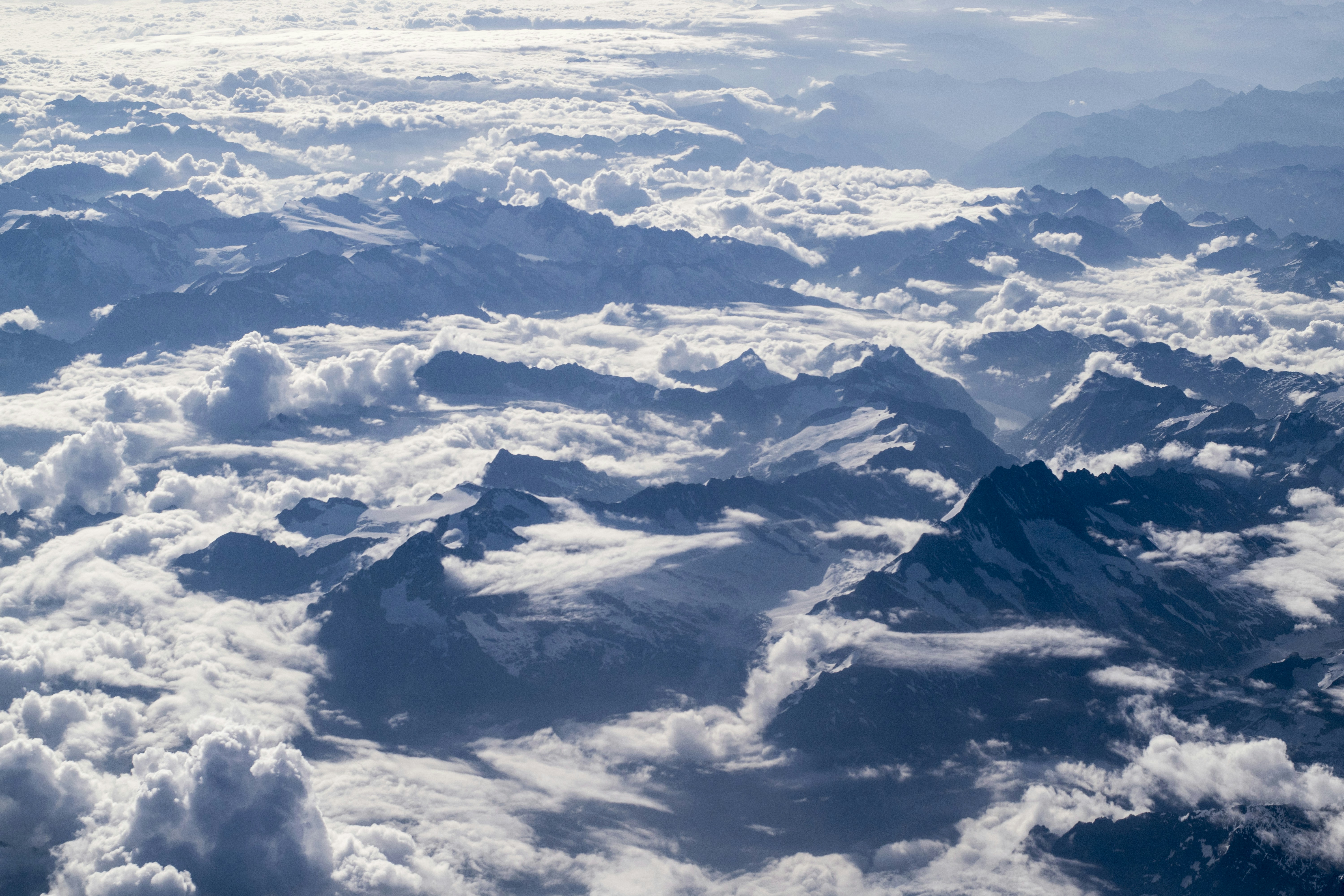 Aerial View of Snow Mountains Above Clouds