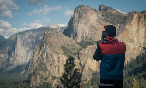 Hiker Photographing Mountain Cliffs