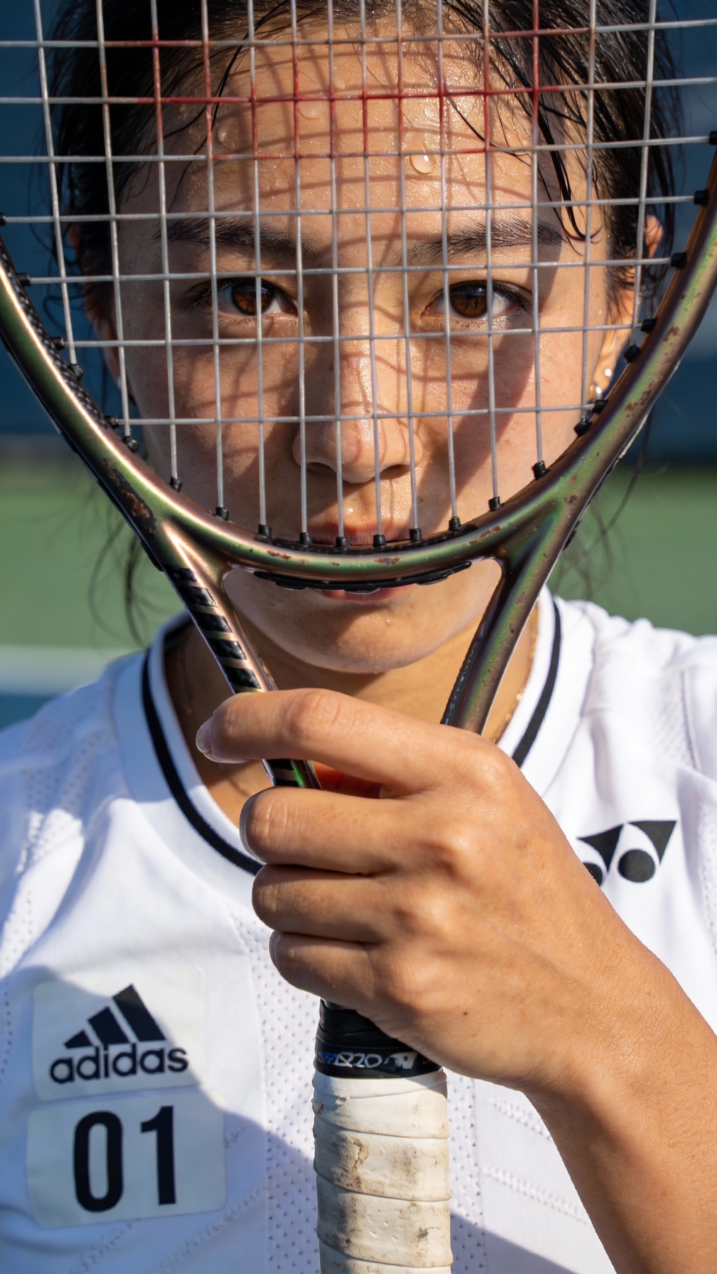 Female Tennis Player Behind Racket