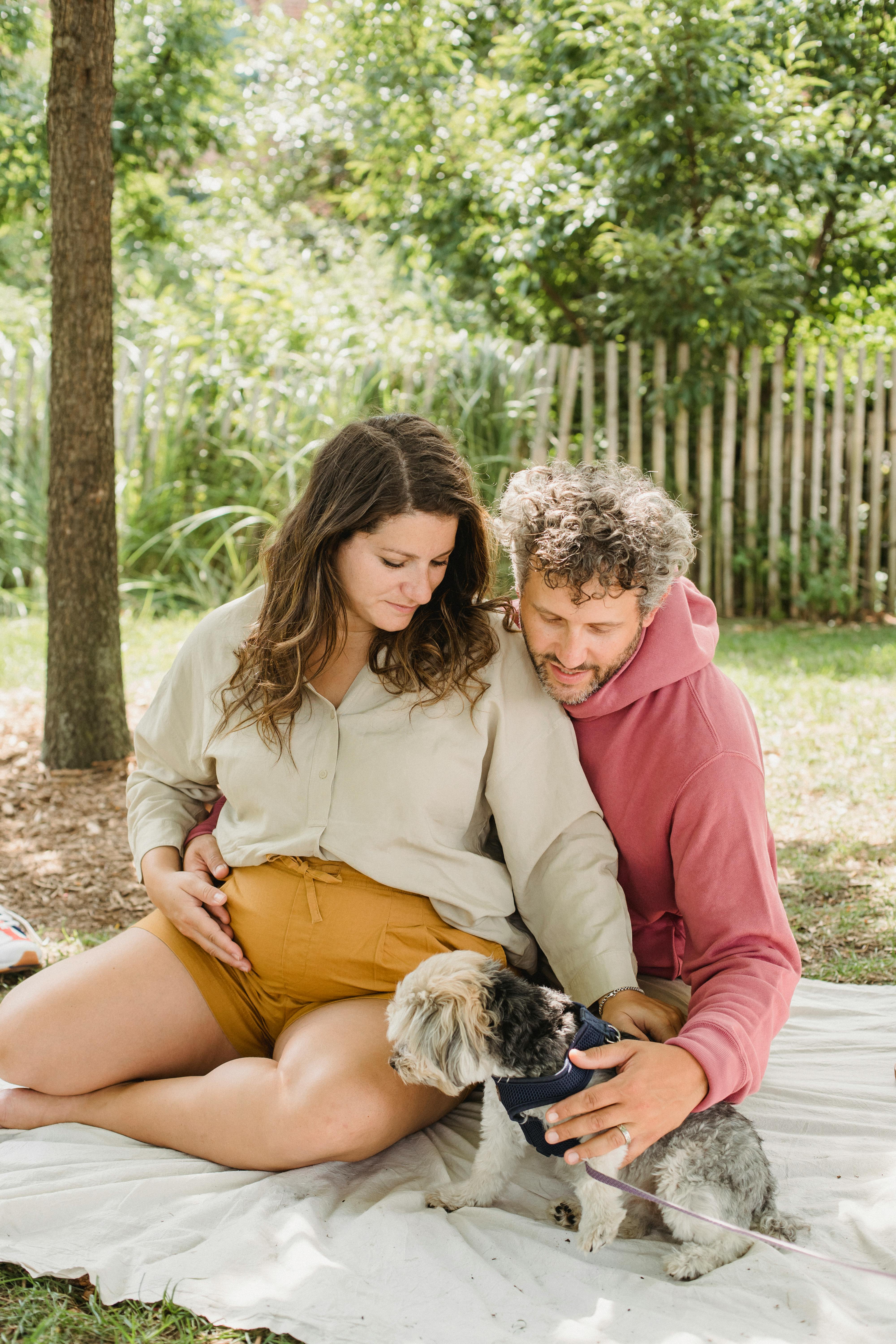 Pregnant Couple With Dog In Backyard