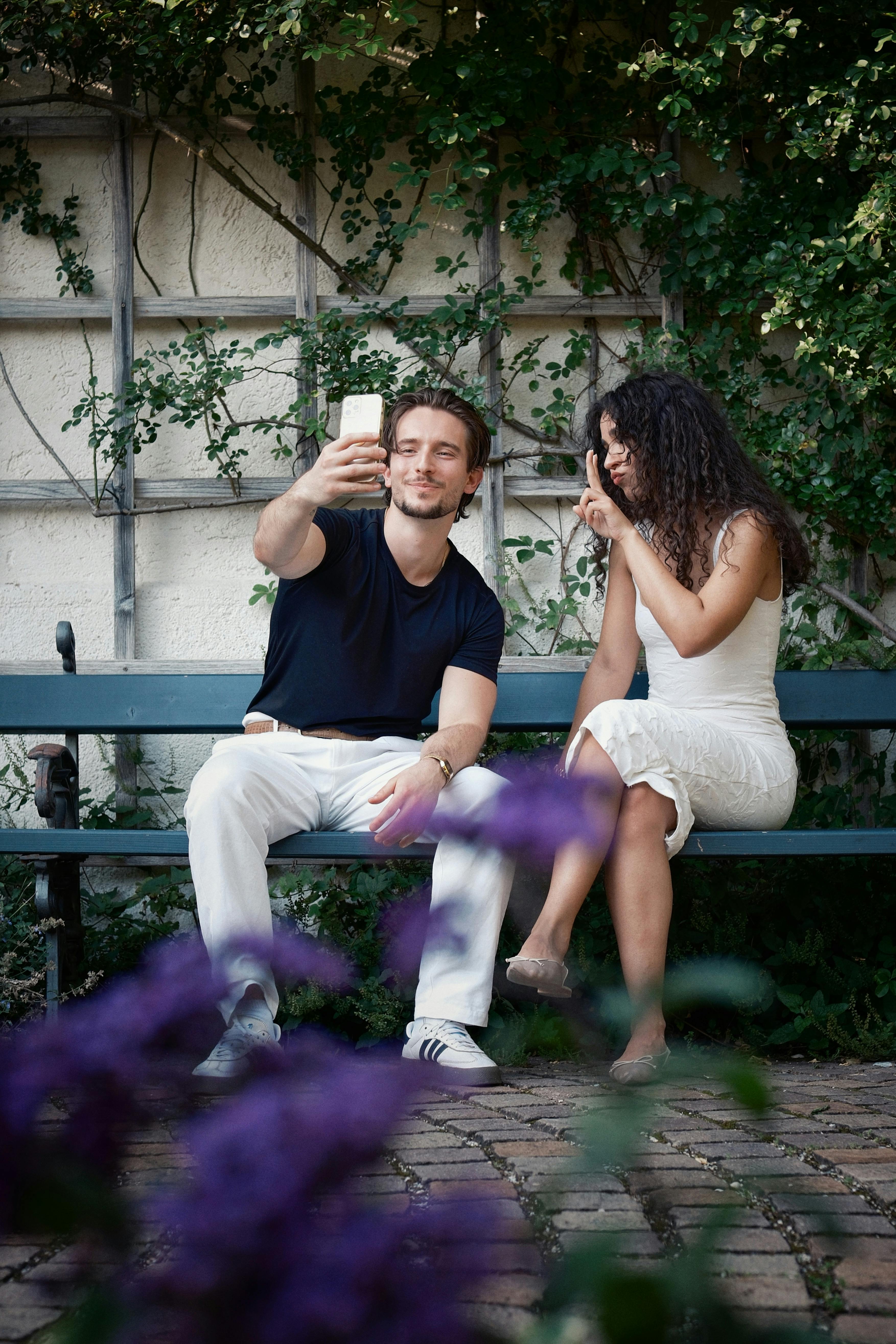 Couple Taking Selfie On Garden Bench
