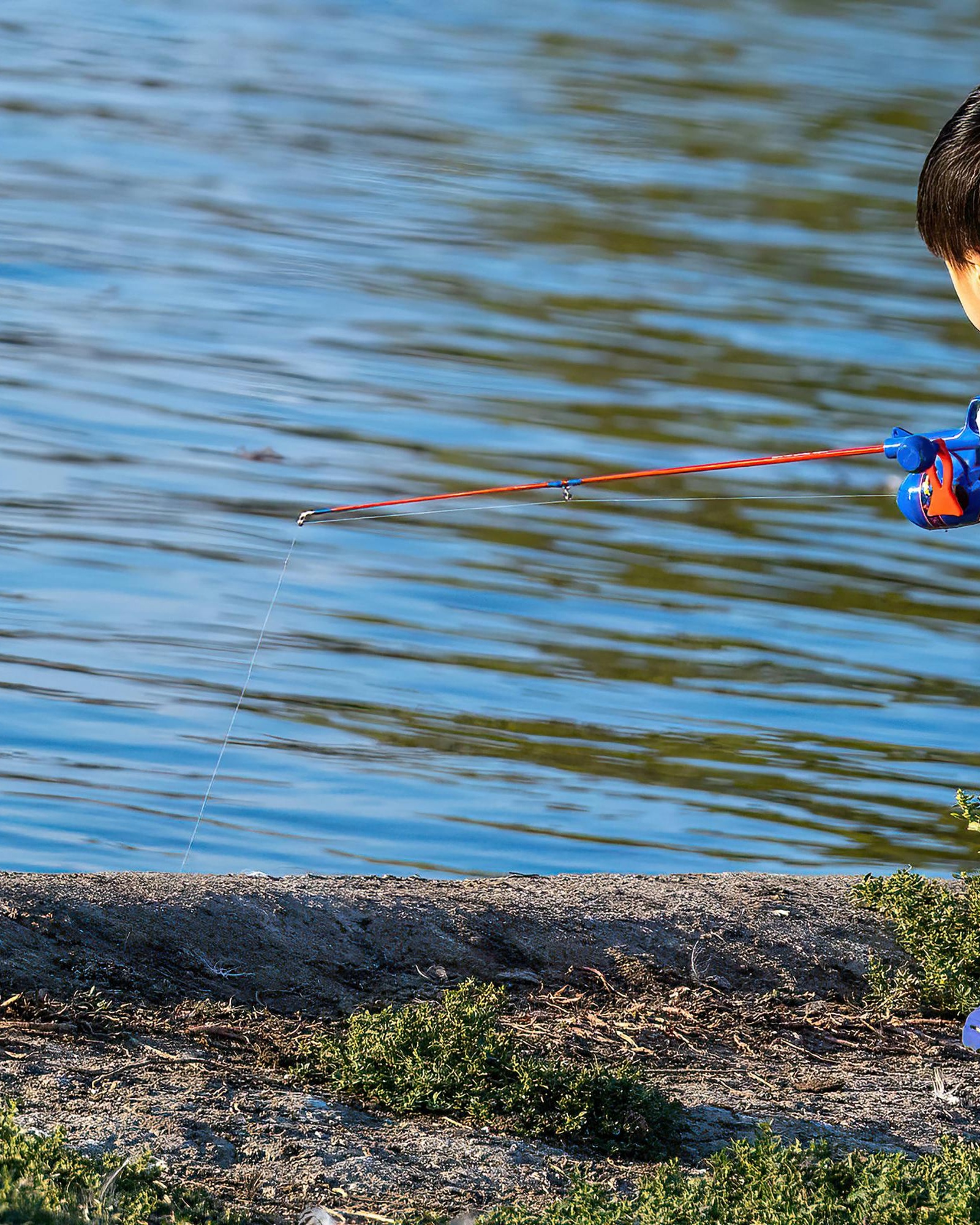 Child Fishing at Water's Edge
