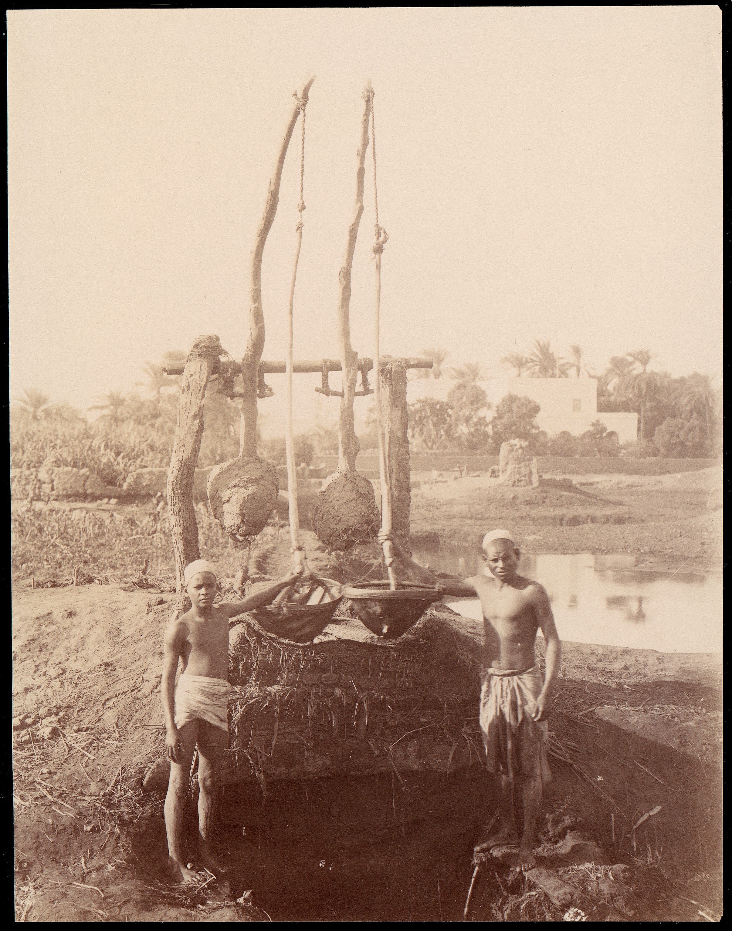 Two Men Operating Traditional Irrigation Device