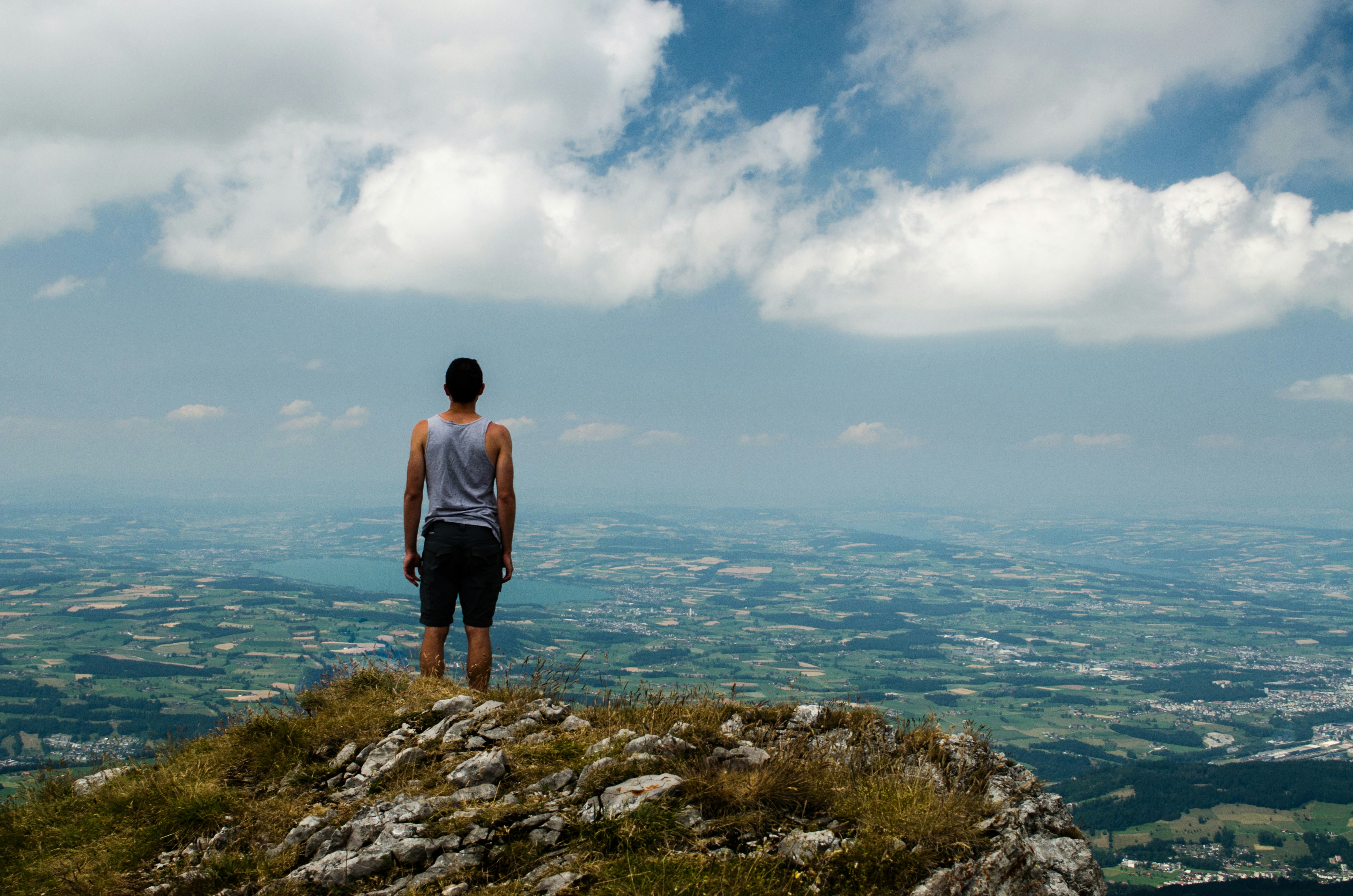 Man Overlooking Plain From Mountain Top