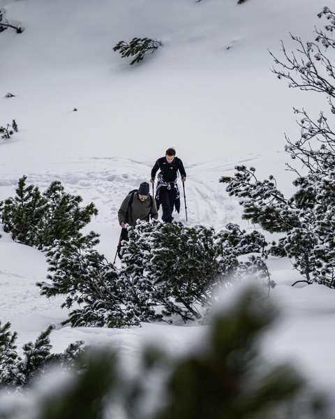 Two Hikers Ascending Snowy Mountain Slope