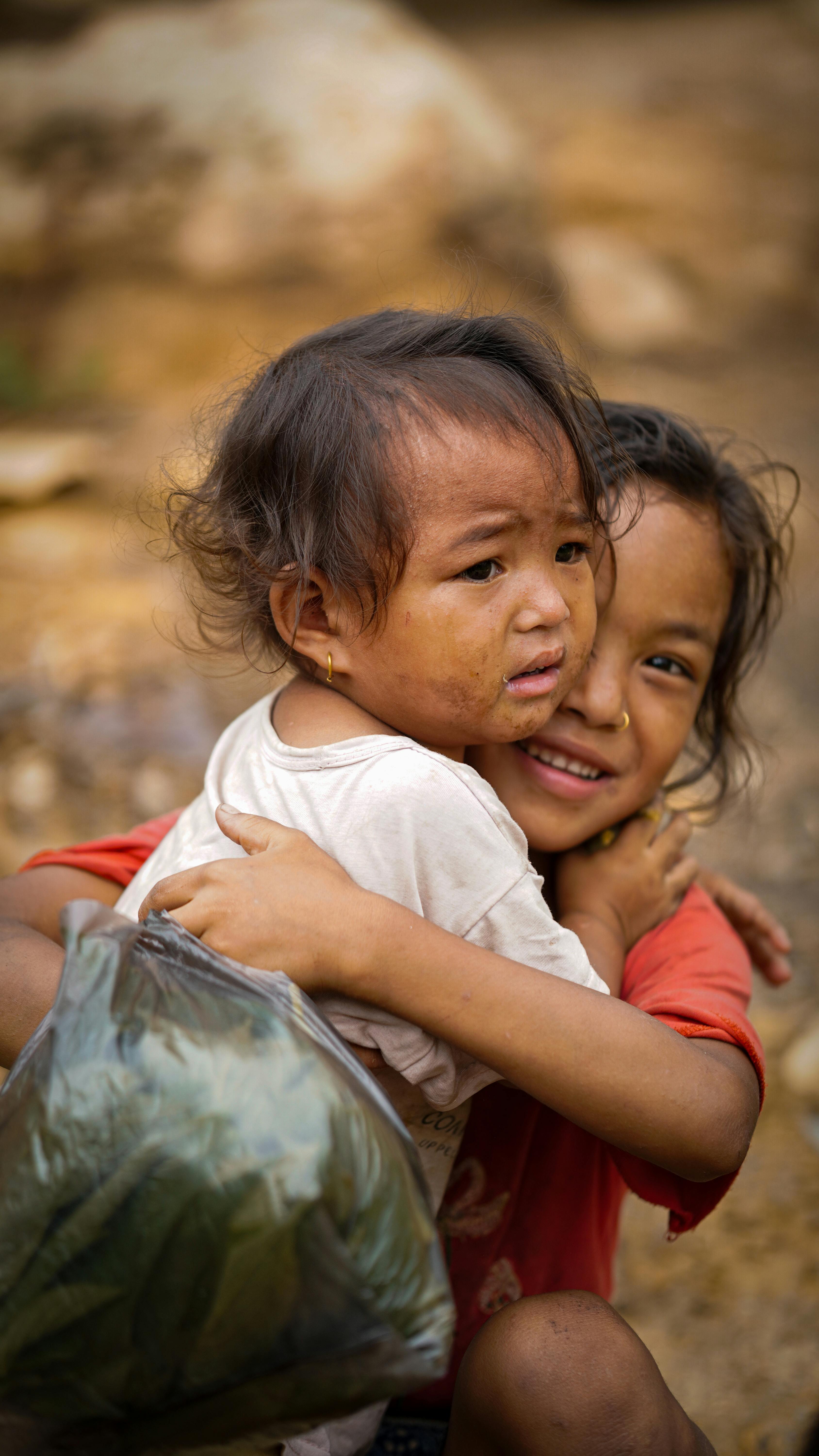 Two Young Children Hugging Outdoors