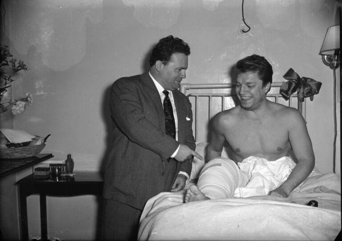 Injured Man Receiving Visit in Hospital Bed