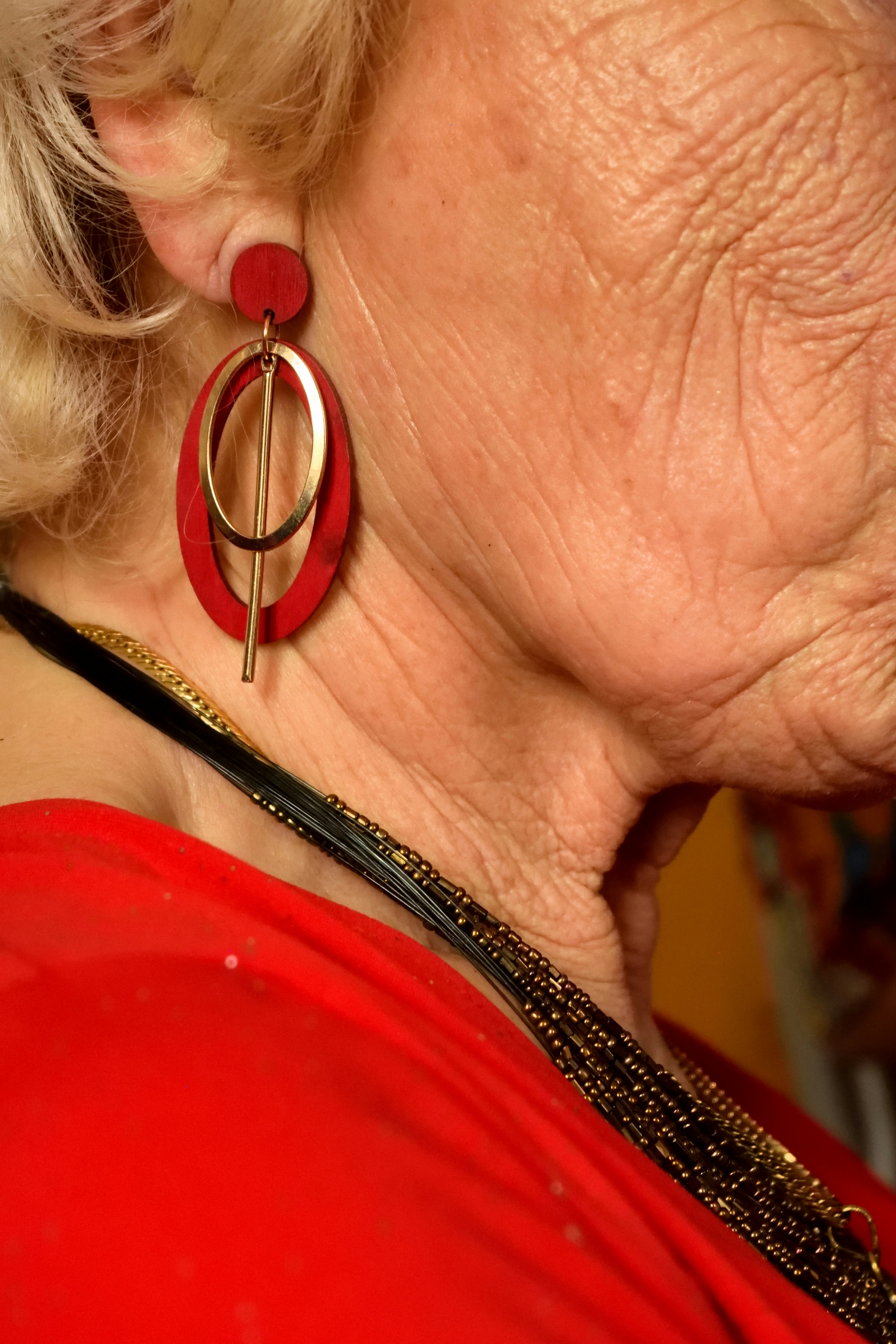 Close Up of Red Statement Earring on Senior Woman