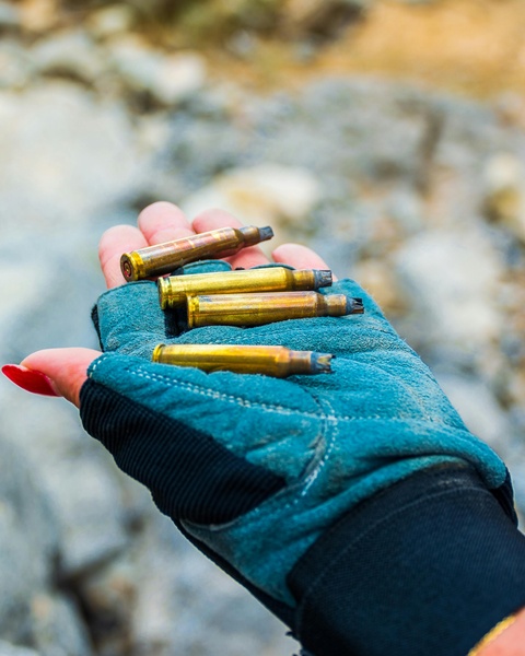 Gloved Hand Holding Spent Bullet Casings