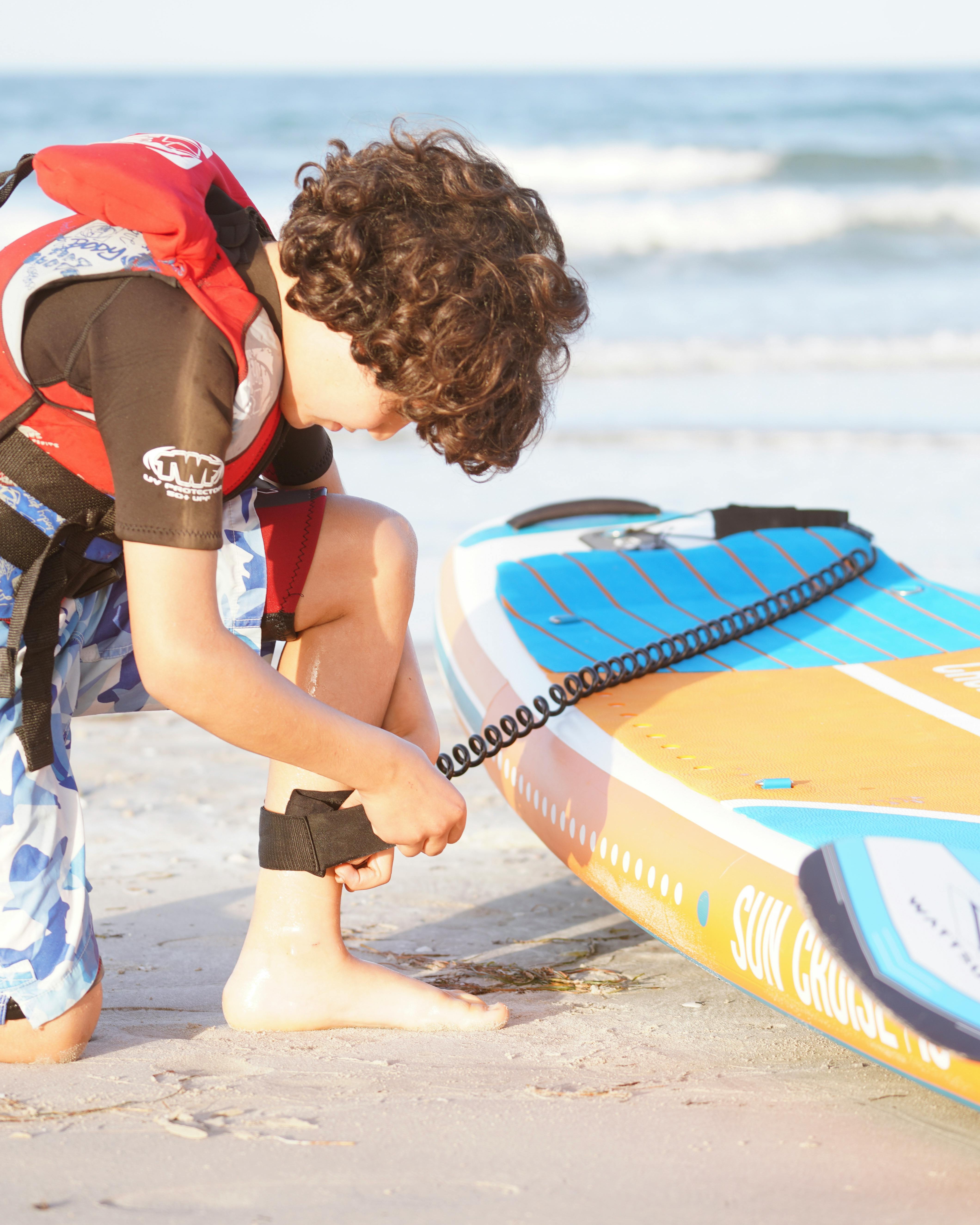 Boy Preparing for Paddle Boarding on Beach