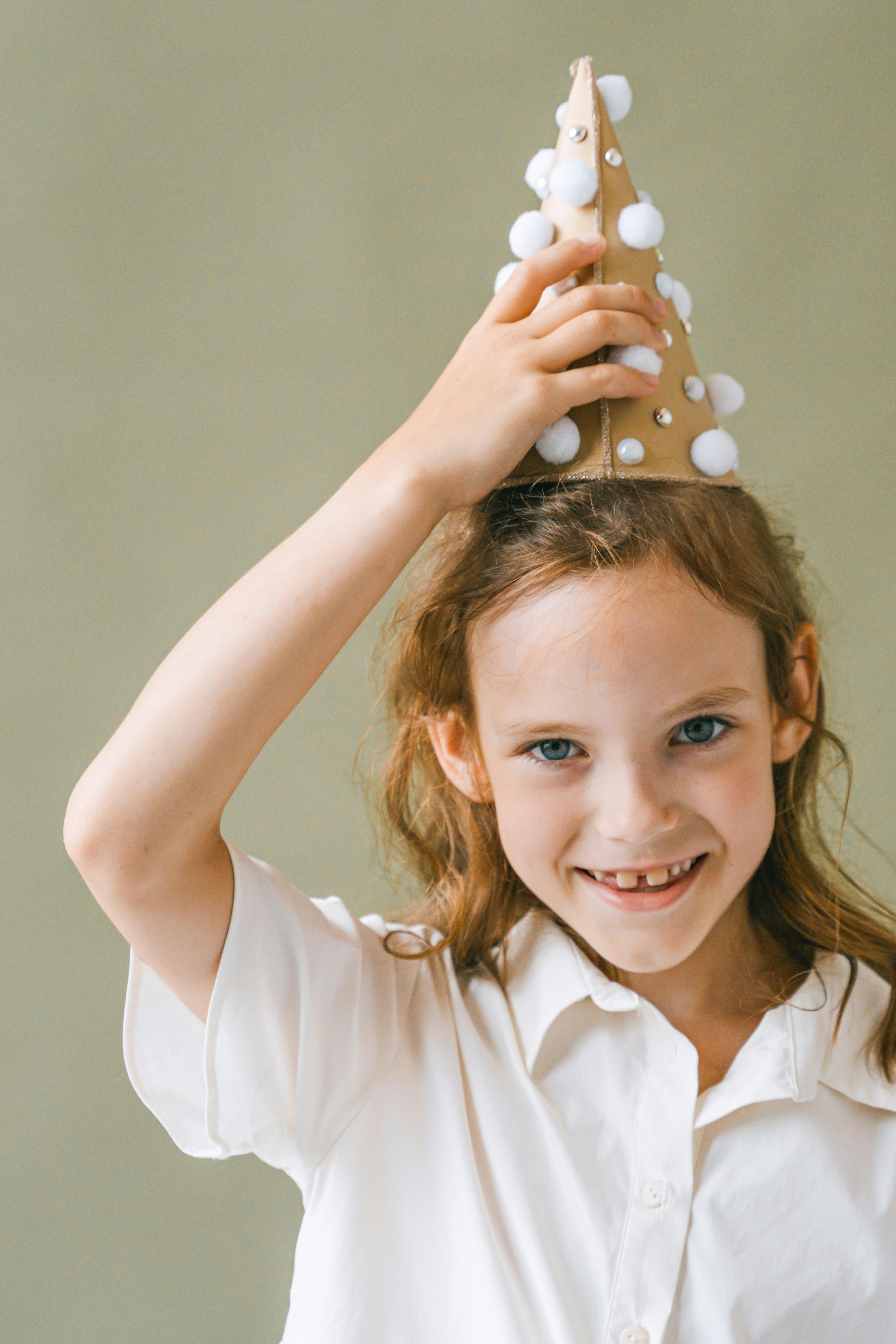 Smiling Girl Holding Decorated Party Hat