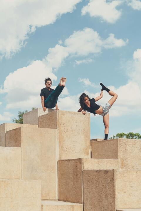 Two People Doing Acrobatic Poses Outdoors