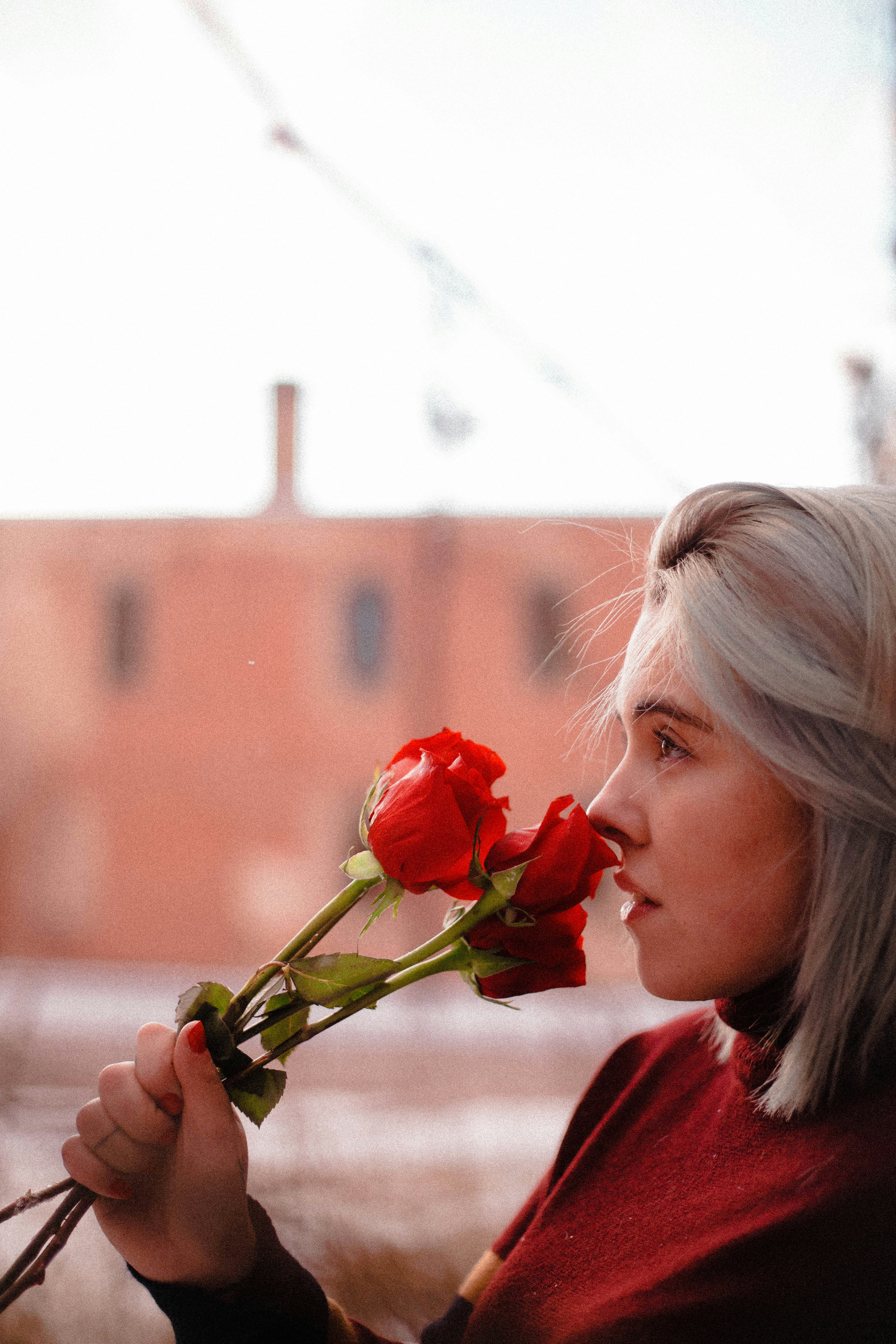 Woman smelling red roses outdoors