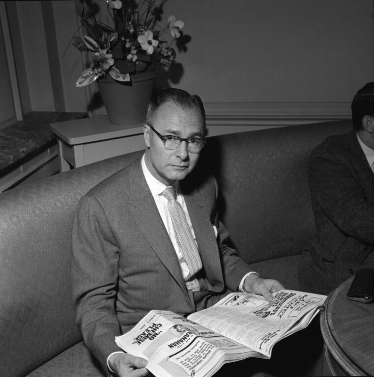 Middle-aged Man Reading Newspaper on Sofa