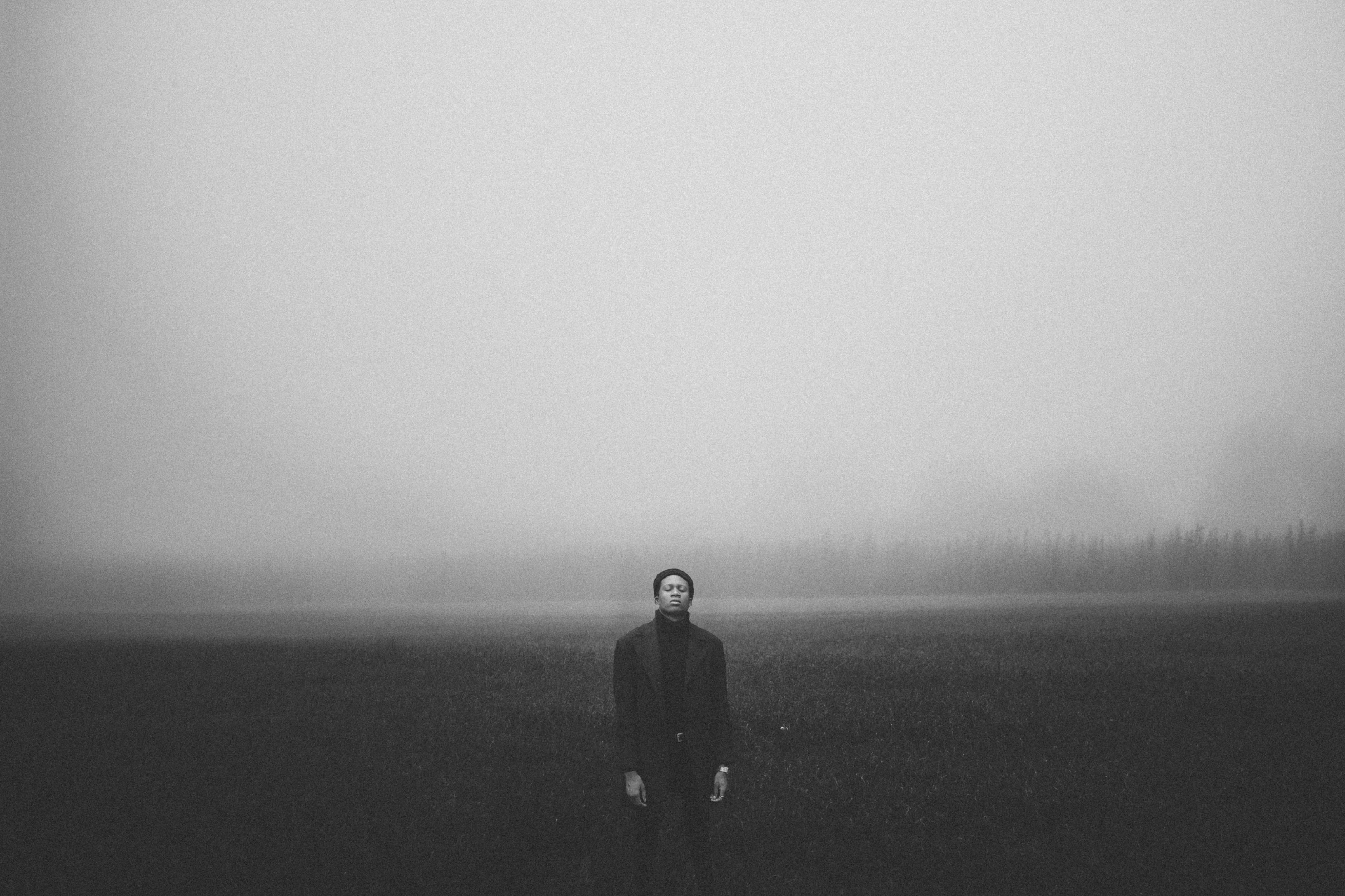 Man Standing in Foggy Open Field