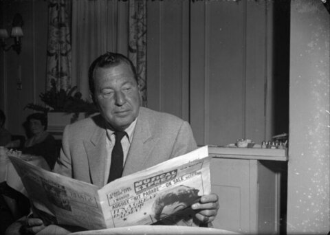 Man Reading Newspaper Indoors