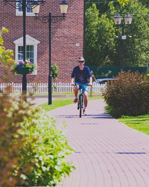 Man Cycling on Residential Path