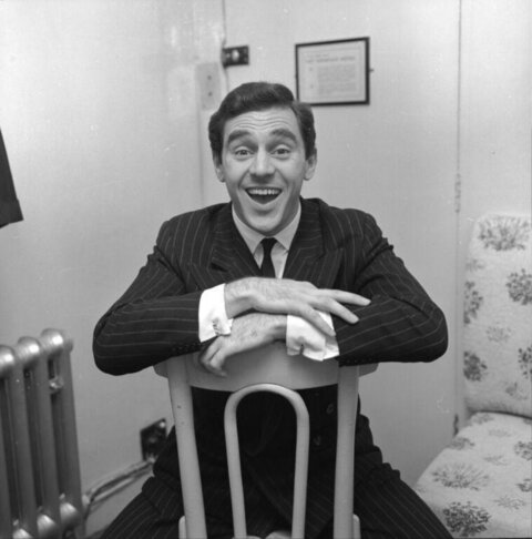 Smiling Man In Suit Sitting Backwards On Chair