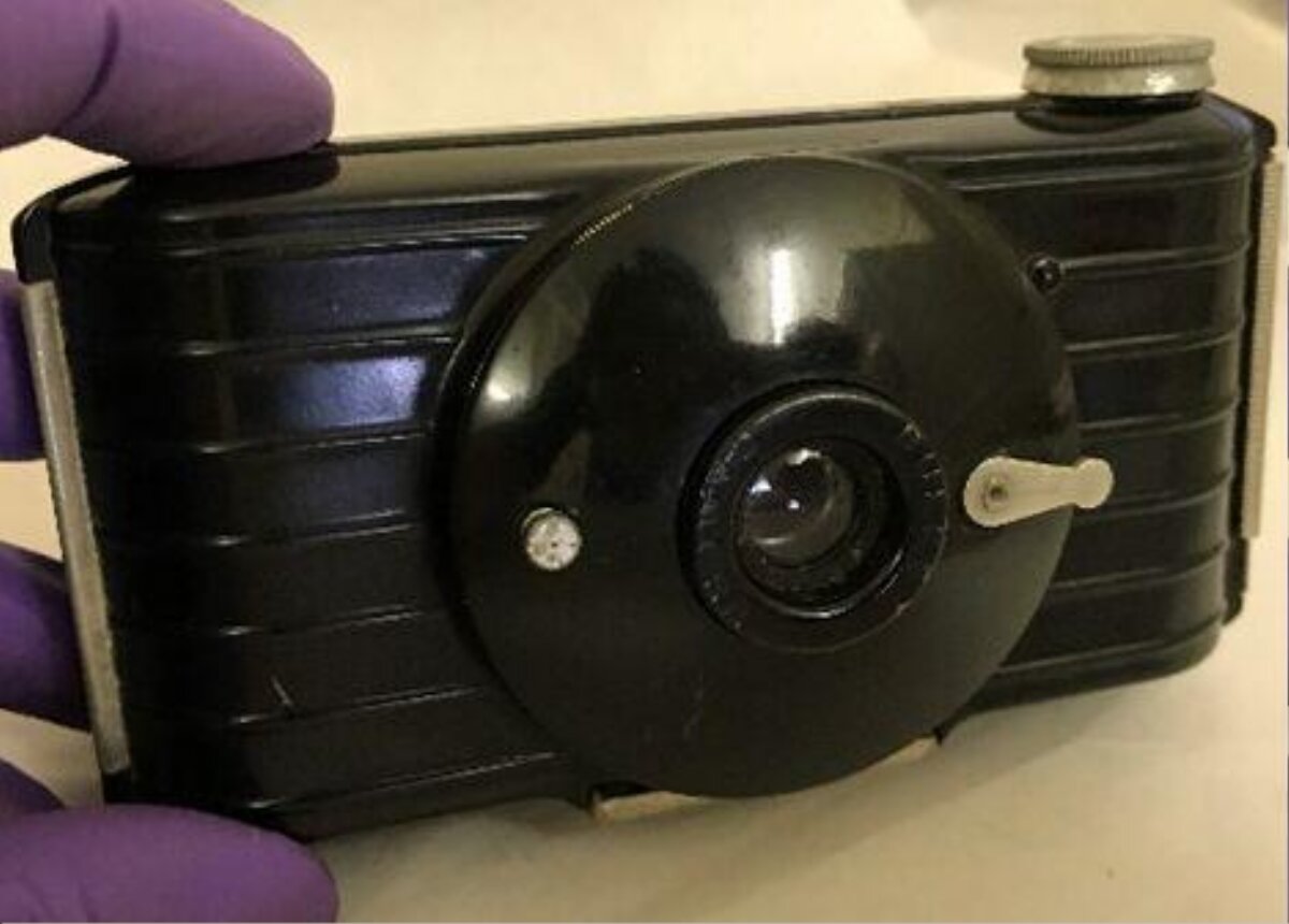 Vintage Black Camera Held by Gloved Hand