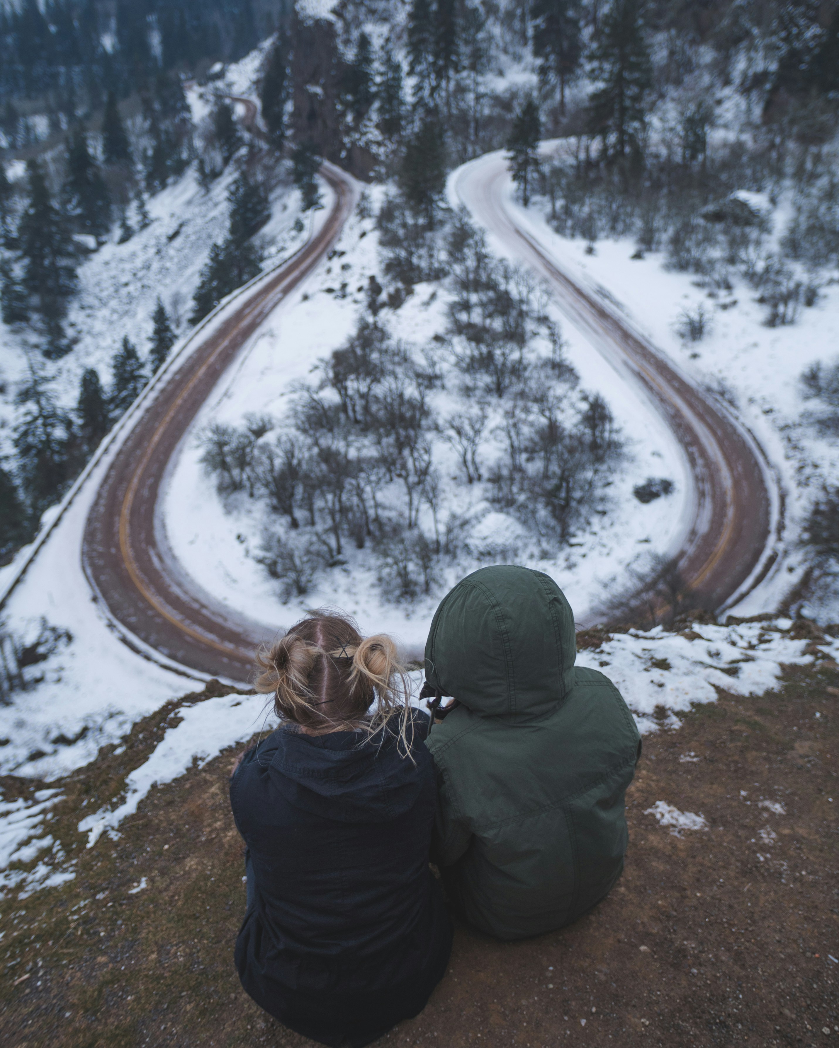 Couple Overlooking Winding Winter Mountain Road