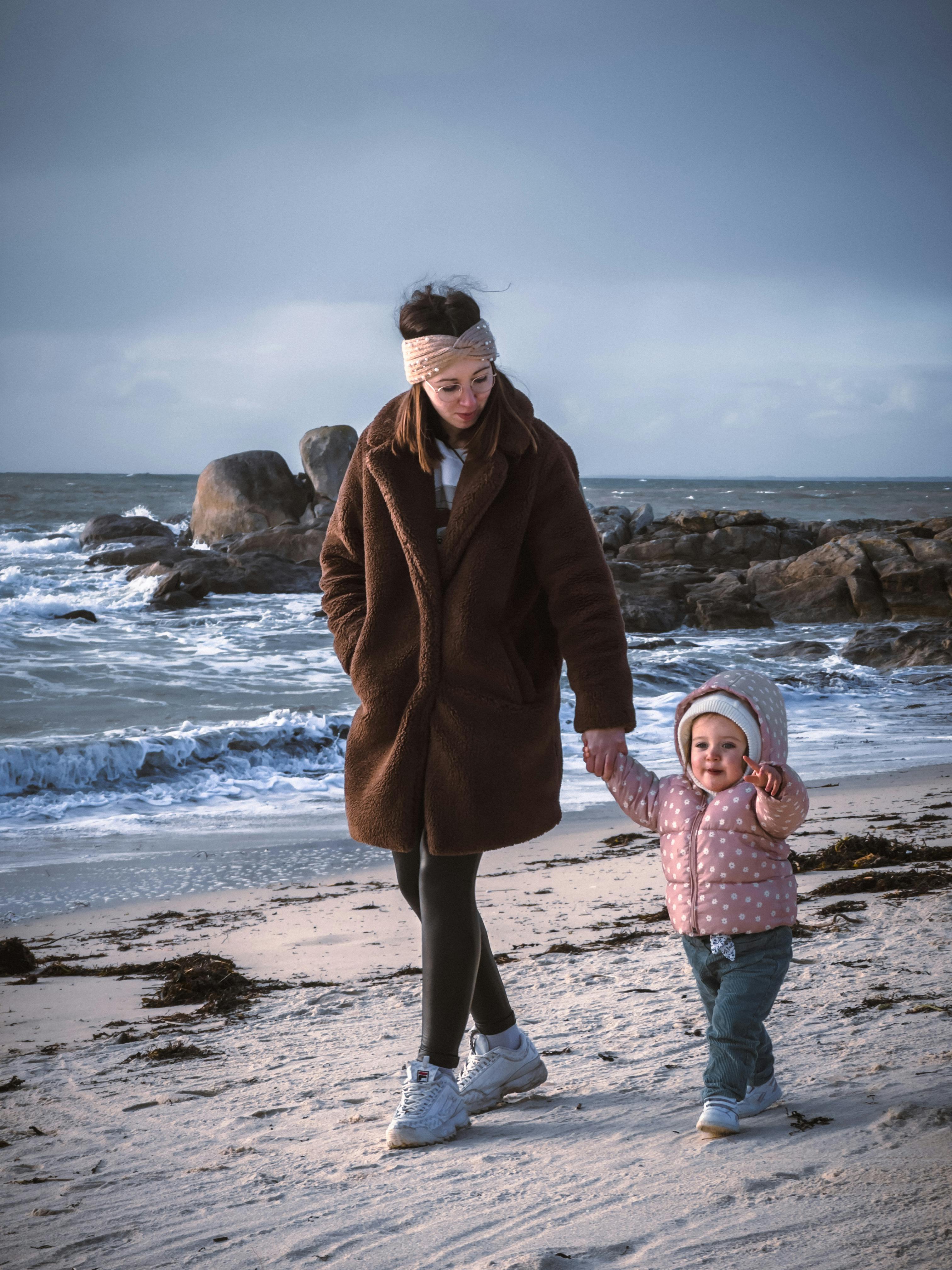 Woman and Toddler Walking on Beach