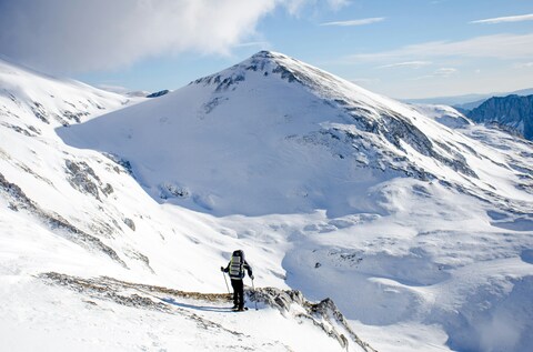 Hiker Climbing Snowy Mountain Peak