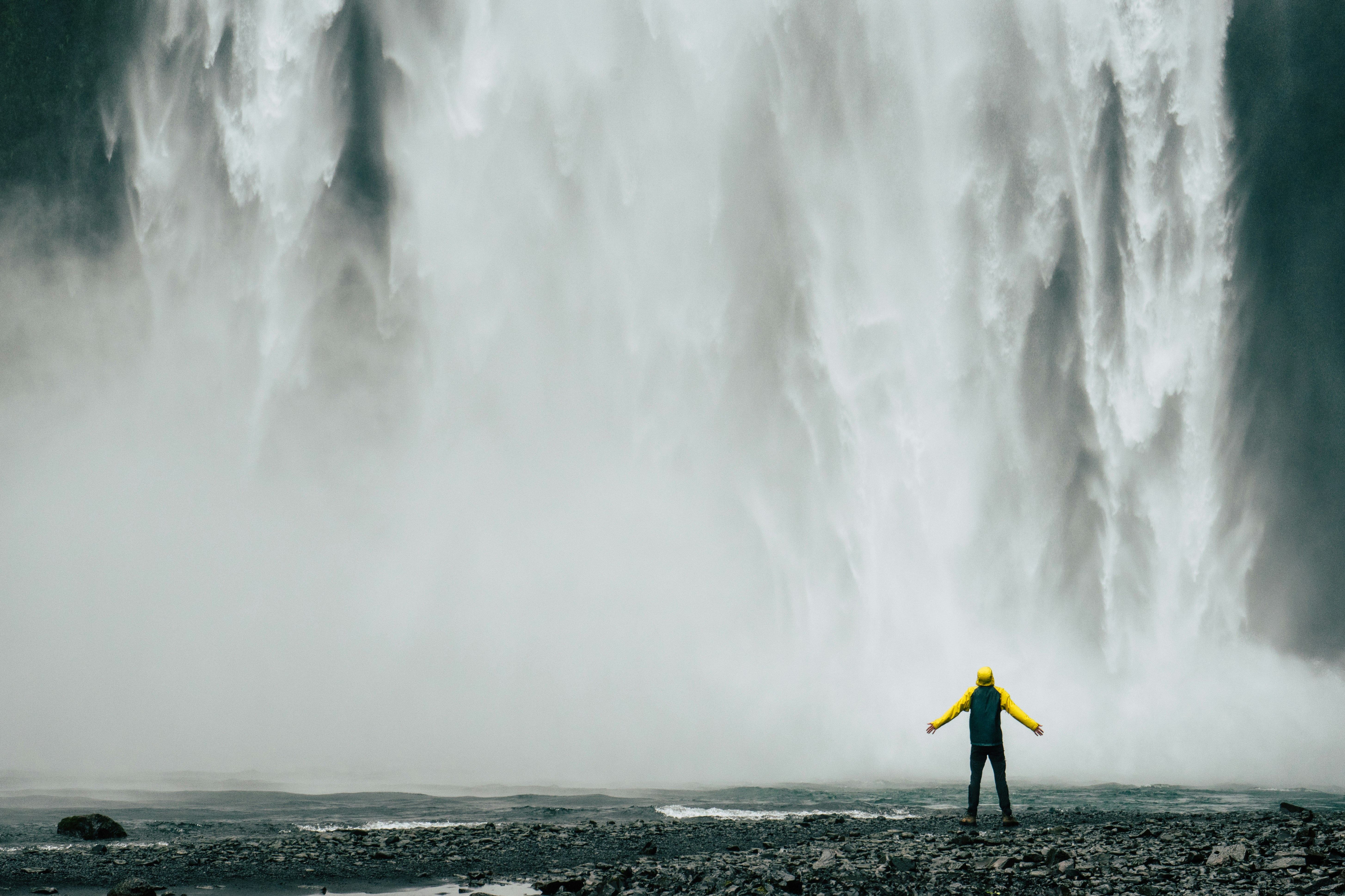 Person Stands Before Large Waterfall
