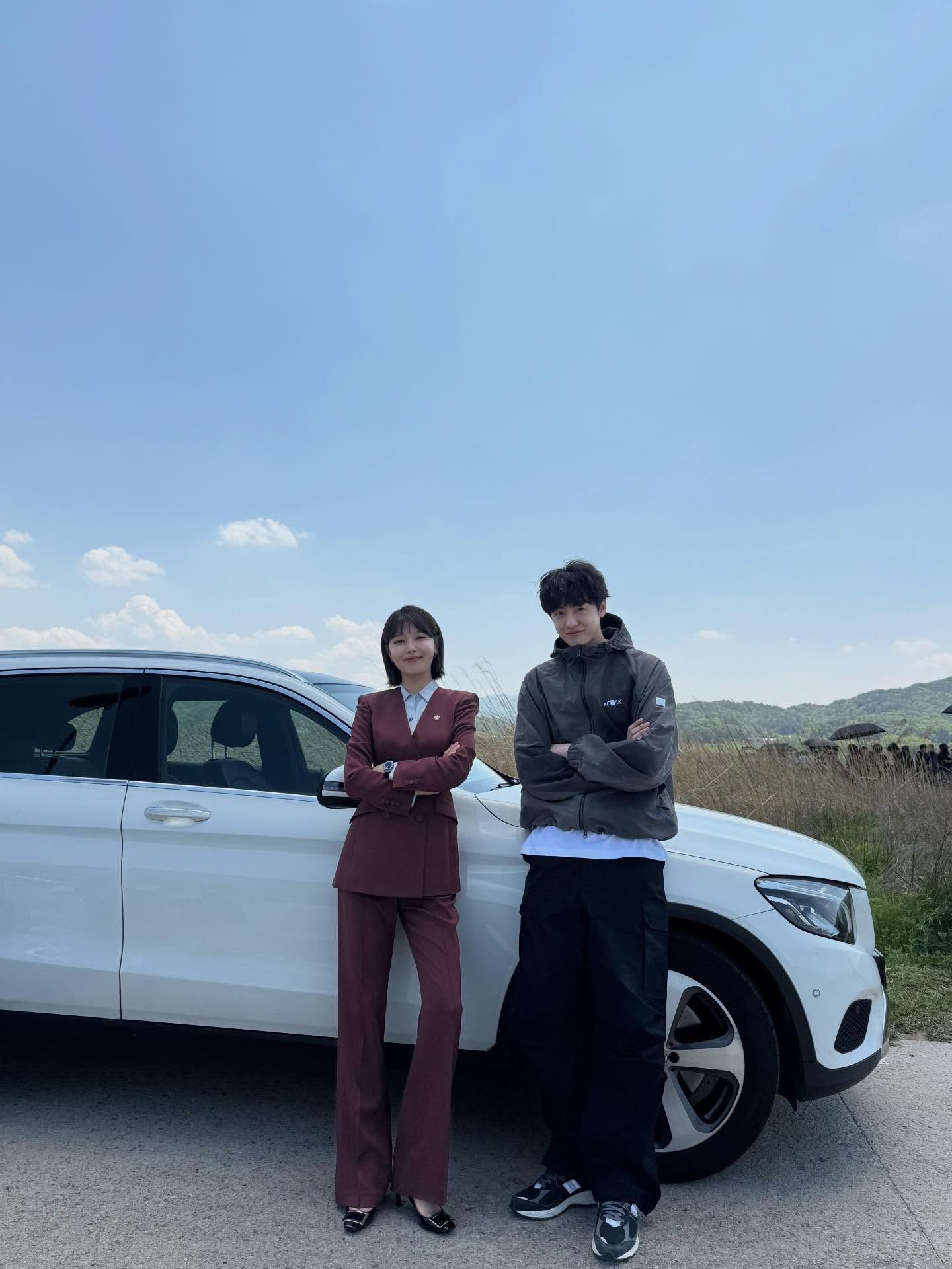 Two People Posing Beside White SUV