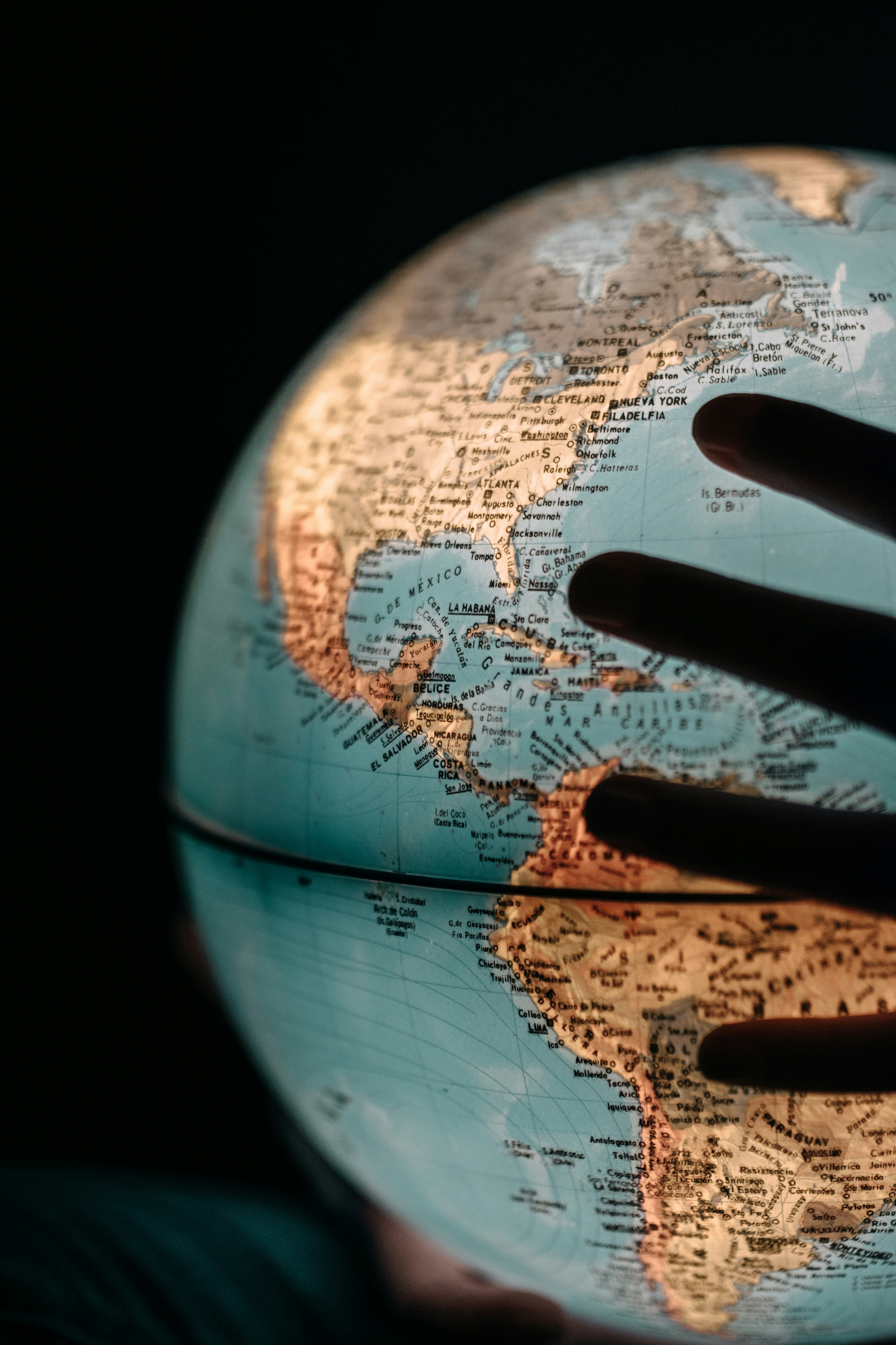 Hand touching illuminated globe