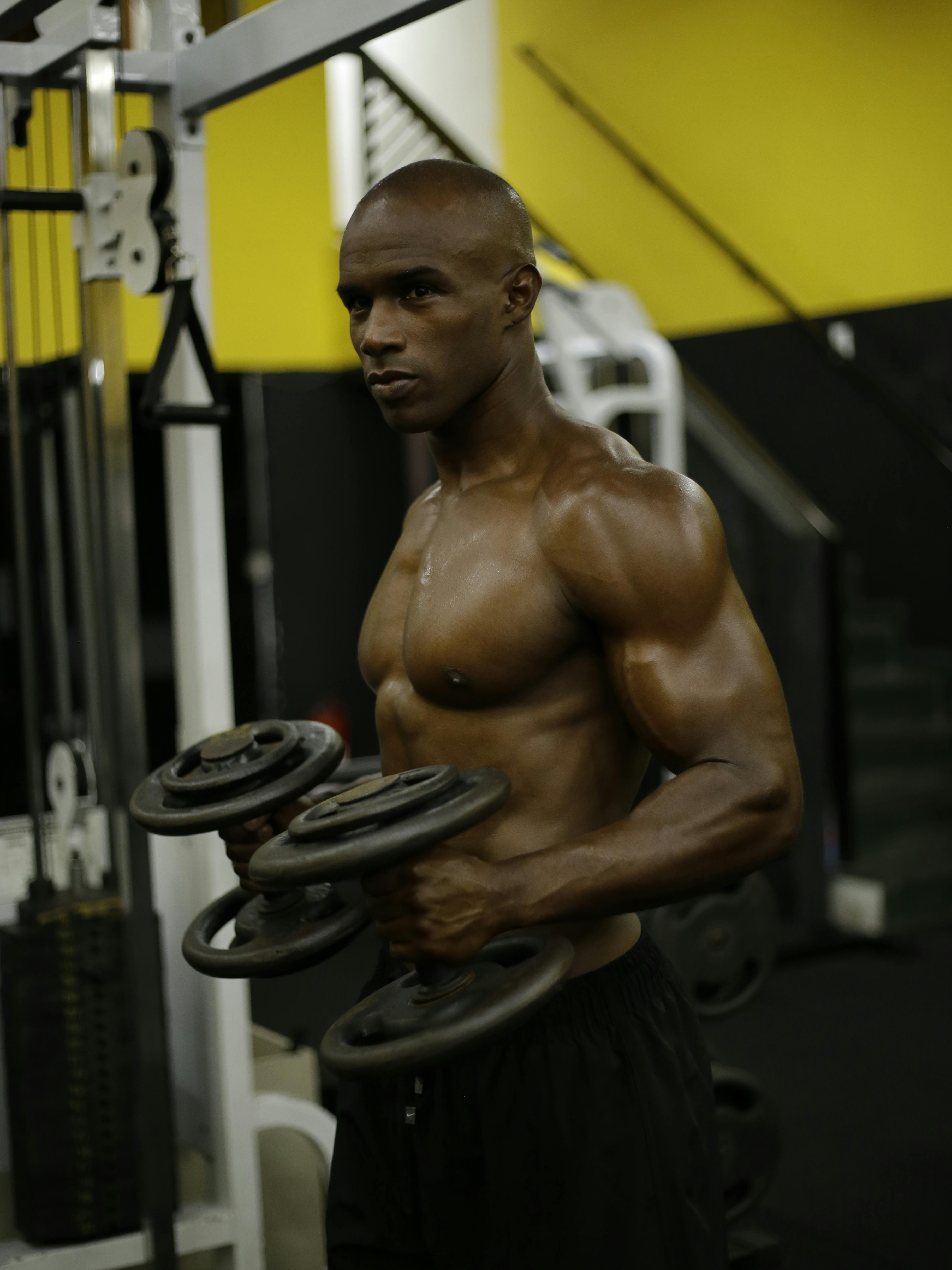 Muscular Man Lifting Dumbbells in Gym