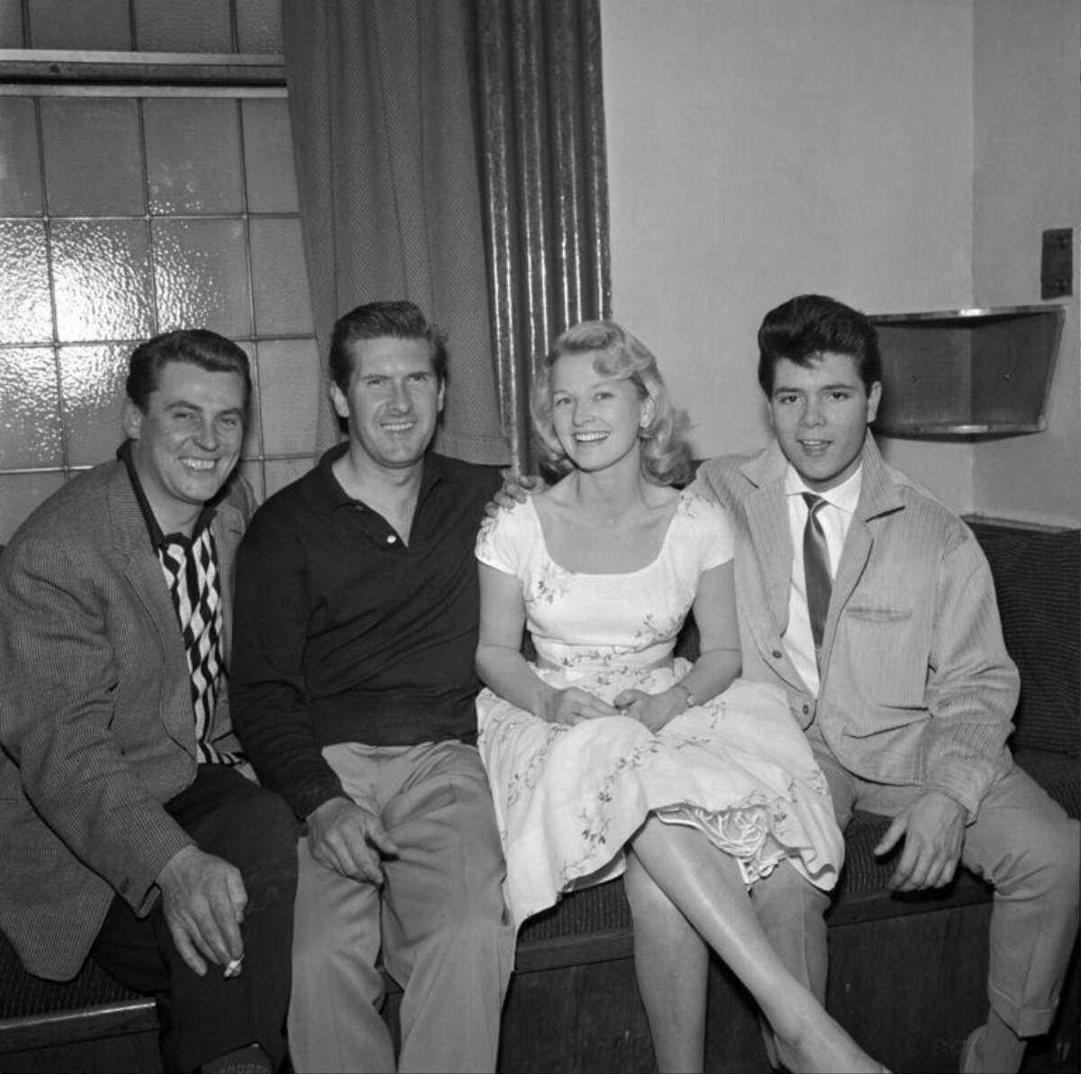 Four Smiling People Posing on a Sofa