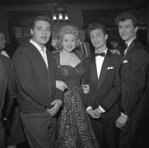 Four people posing at an indoor event