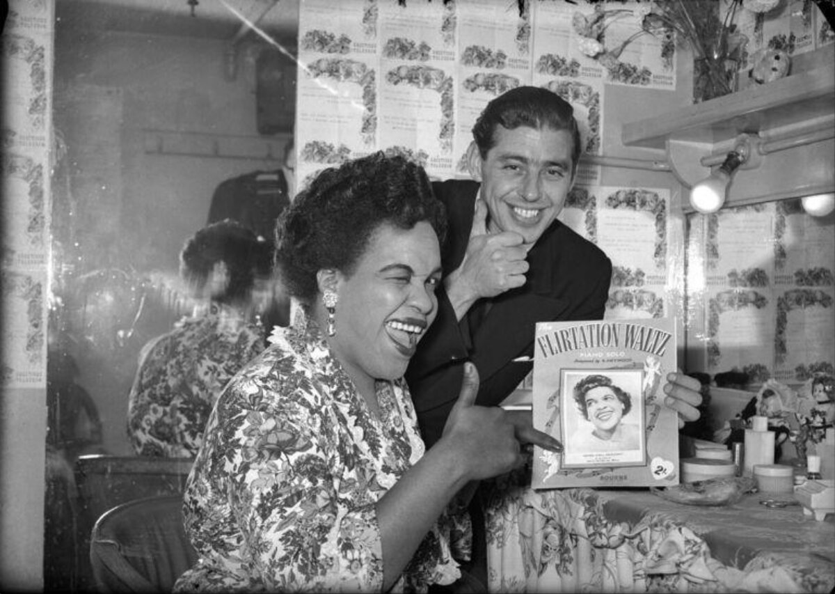 Singer and Man Pose With Her Sheet Music