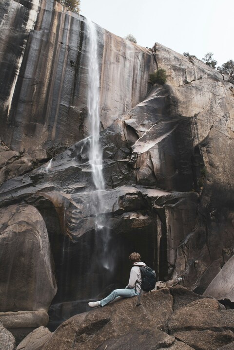 Hiker Resting at Mountain Waterfall
