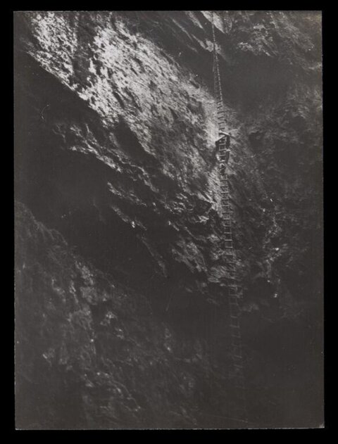 Climber on Steep Cliff Rope Ladder