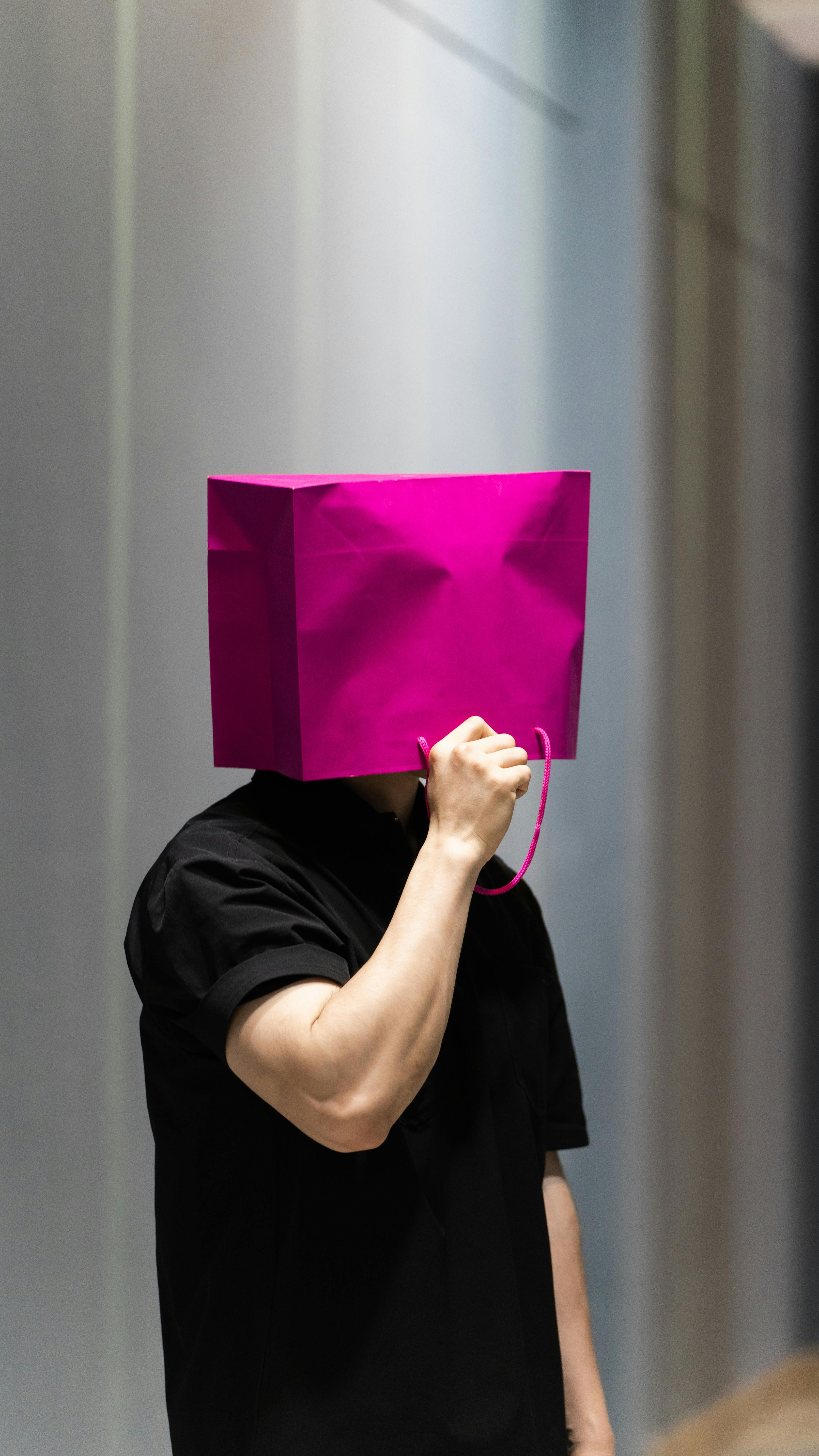 Person Holding Pink Bag Over Head