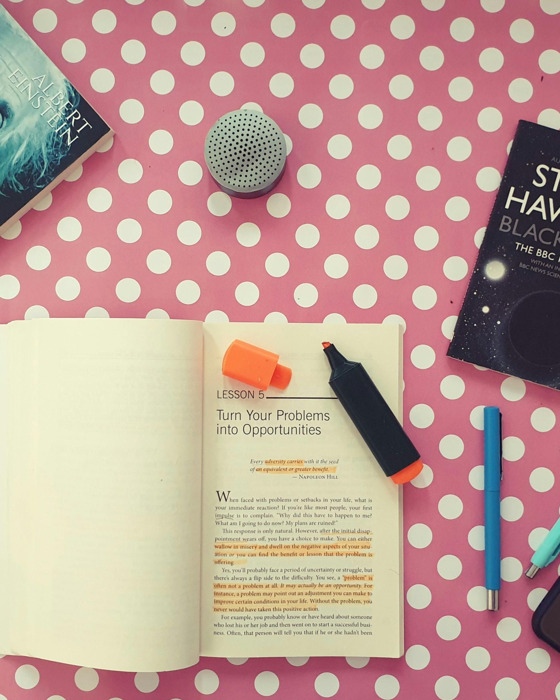 Open Motivational Book on Pink Polka Dot Table