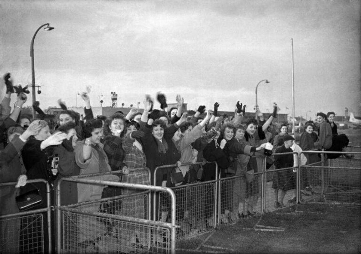 Crowd of Women Waving at Airport