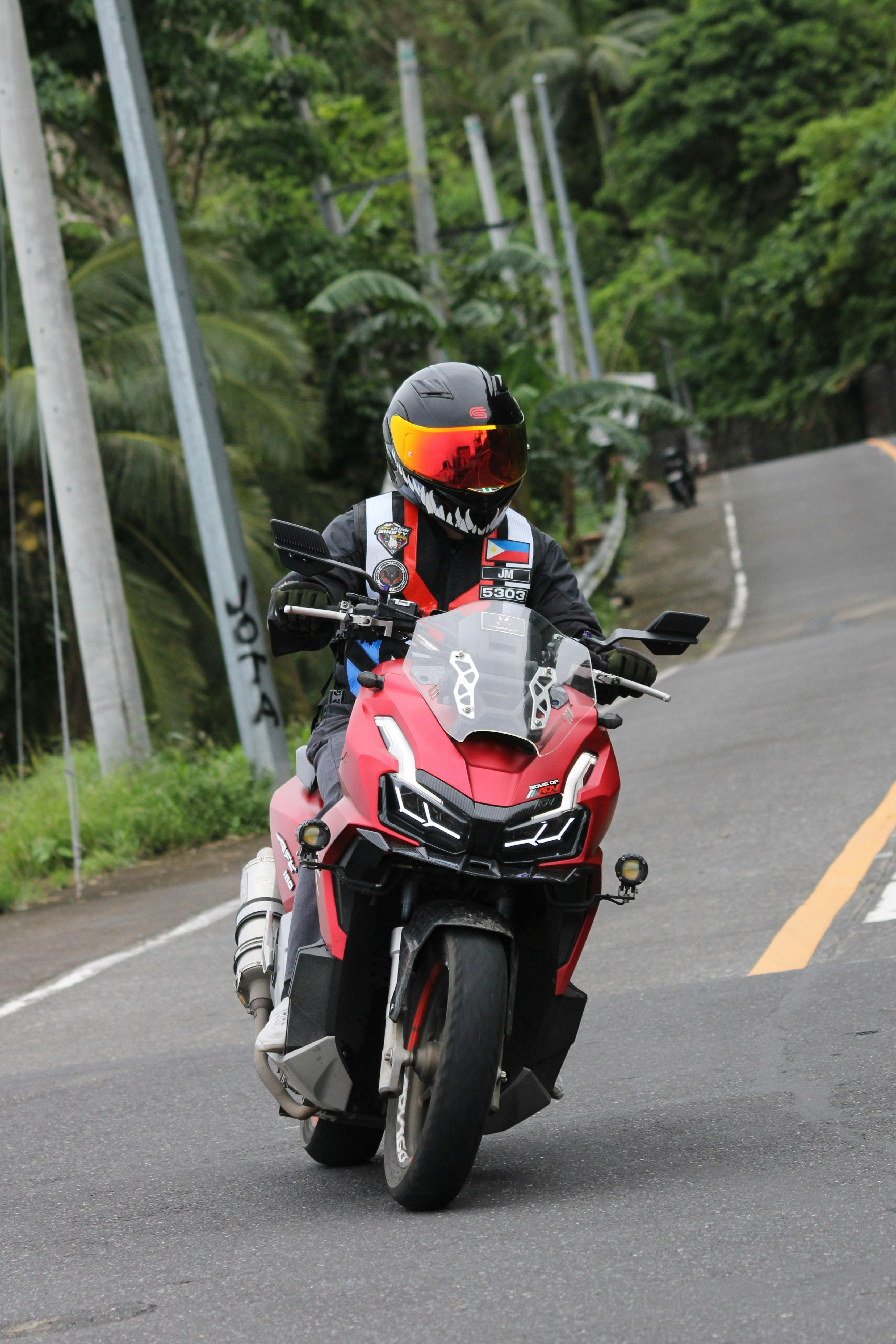 Motorcyclist Riding Red Motorcycle on Winding Road