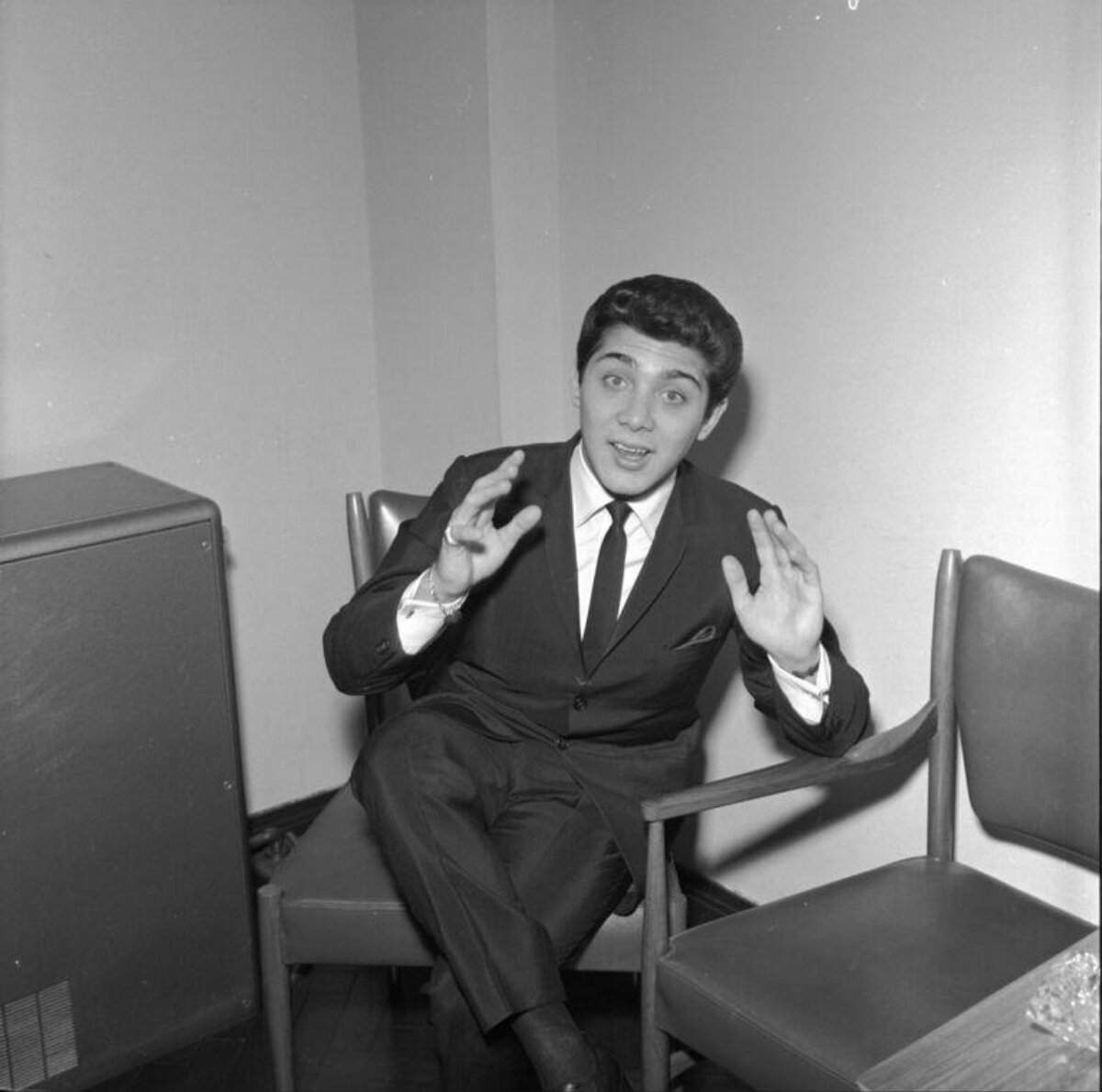Suited Man Gesturing While Seated