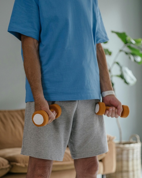 Senior Exercising With Dumbbells At Home