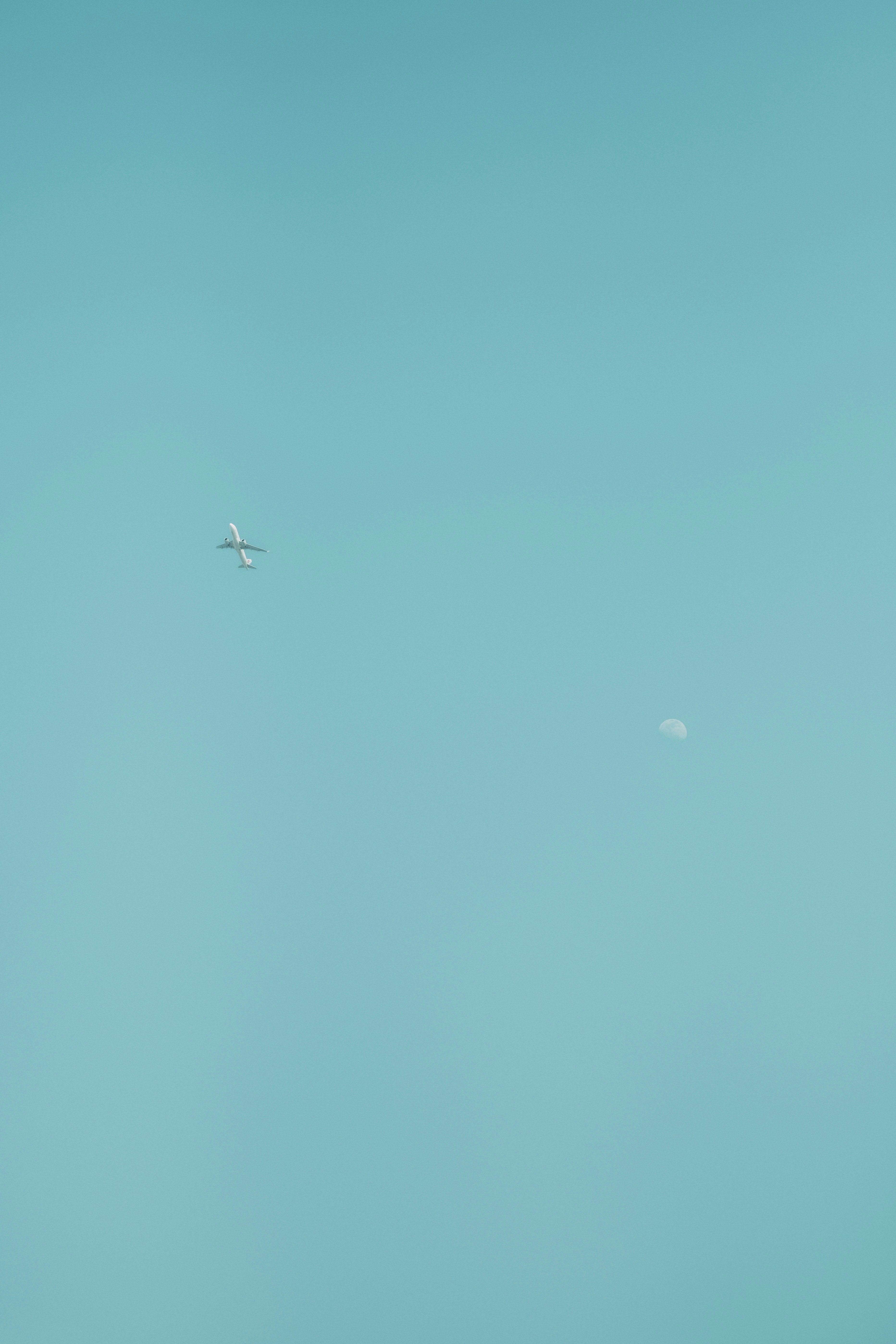 Airplane and Moon in Clear Sky