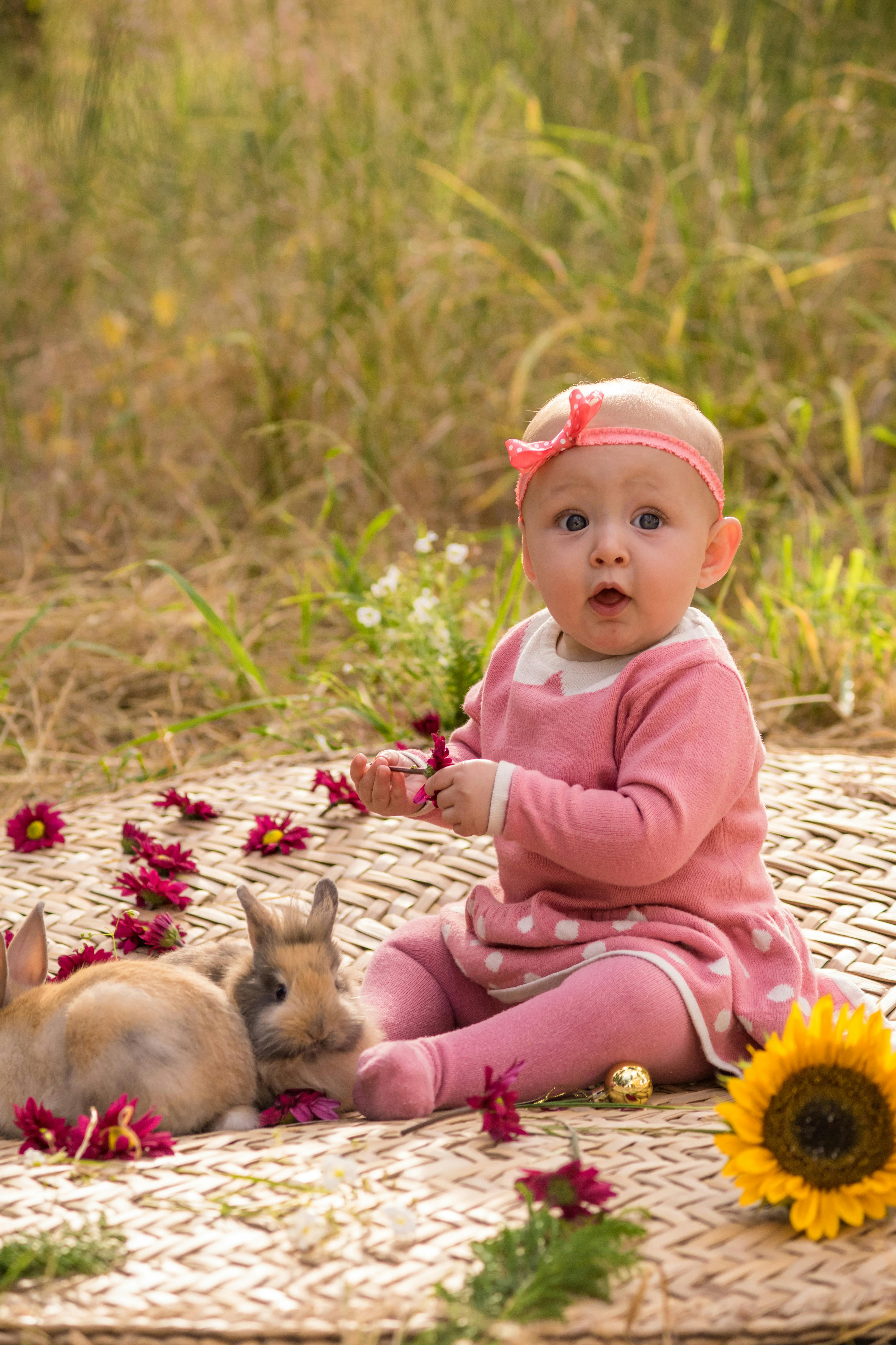 Baby Girl With Two Bunnies Outdoors